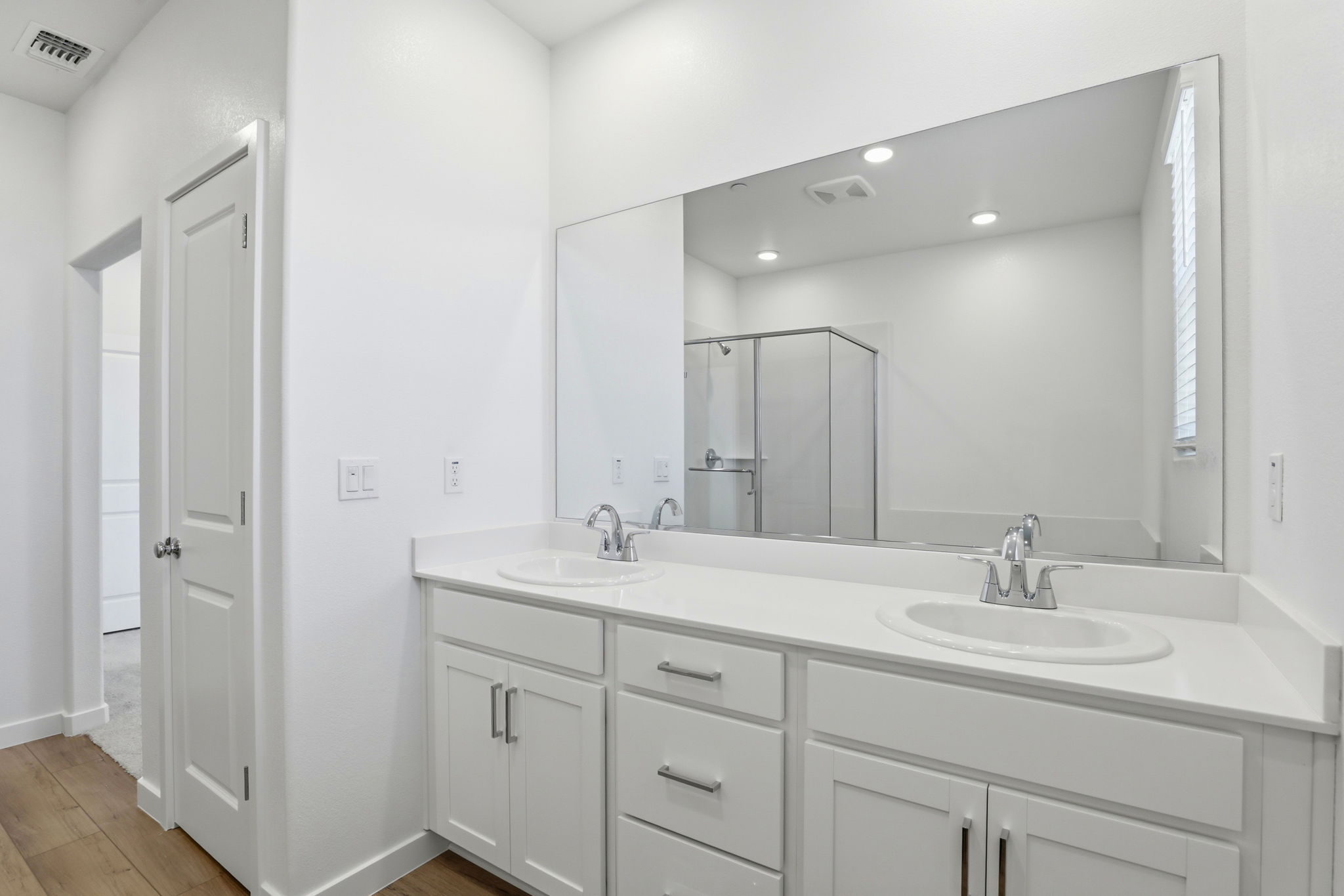 A bathroom with white cabinets.