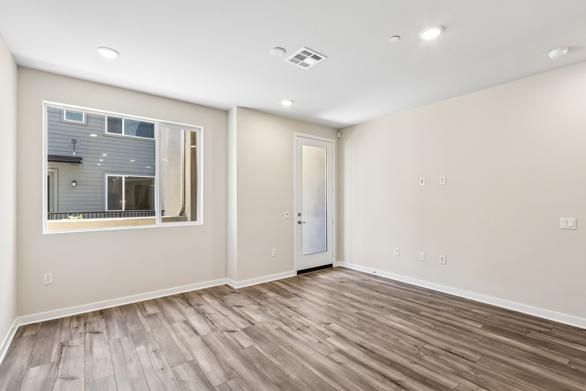 A room with a wood floor and a window.
