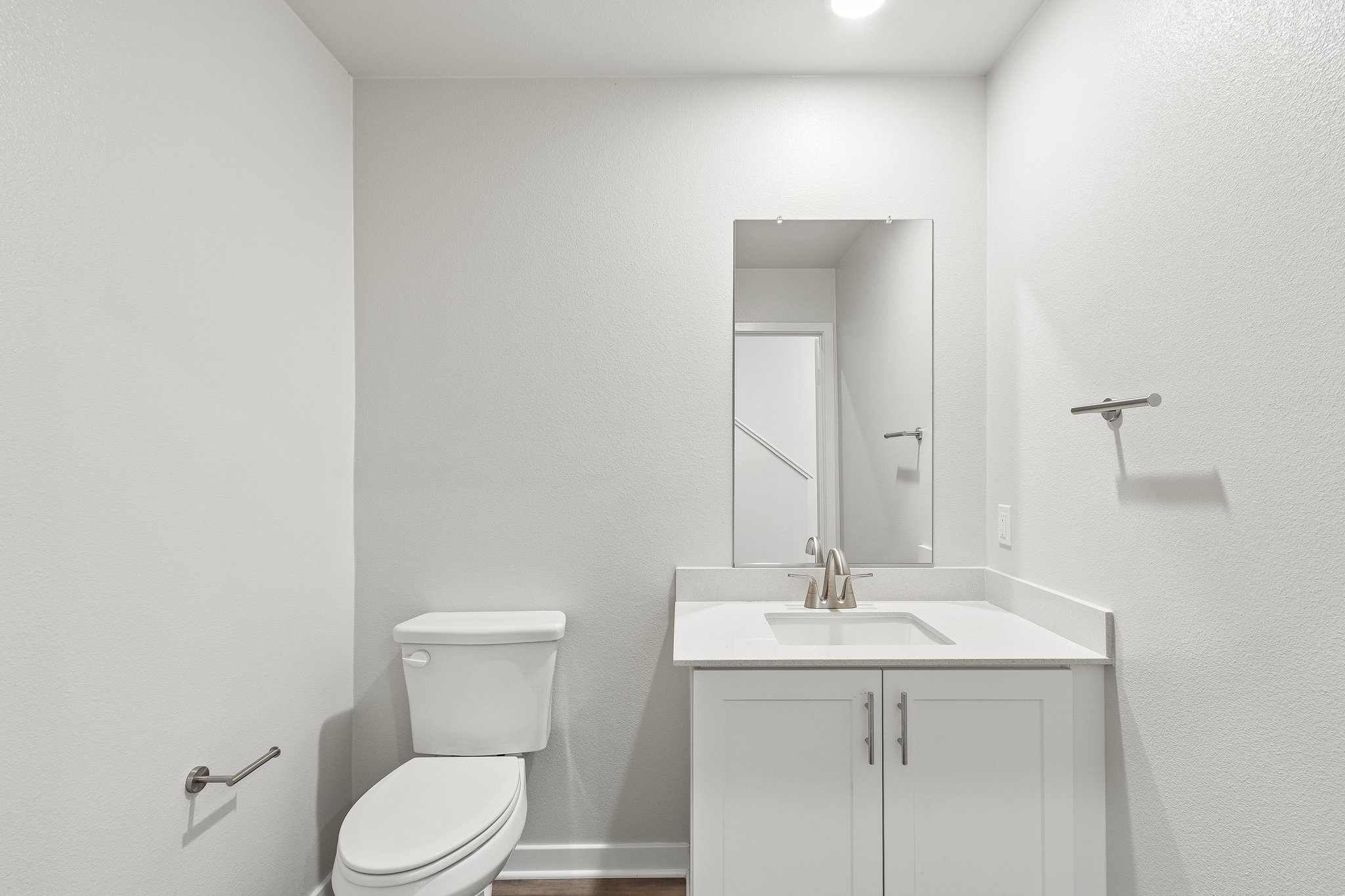 A bathroom with a toilet sink and mirror.