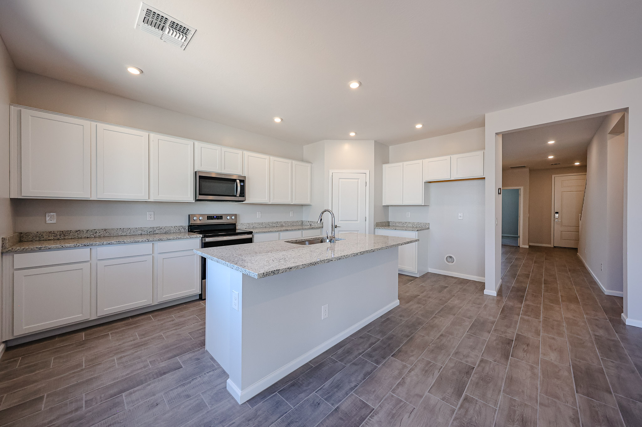 A kitchen with white cabinets.