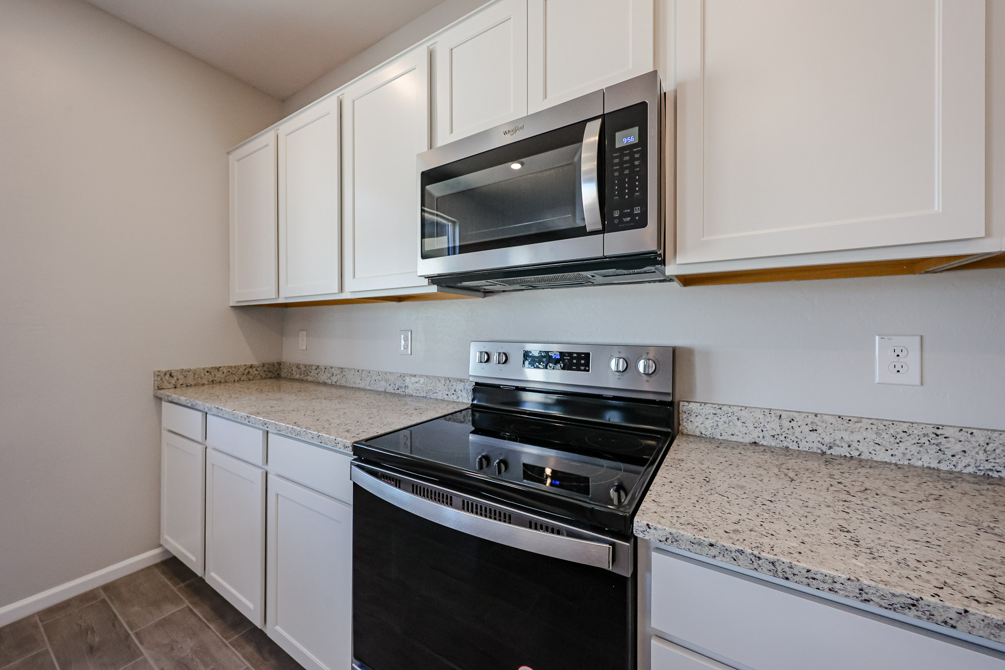 A kitchen with white cabinets.
