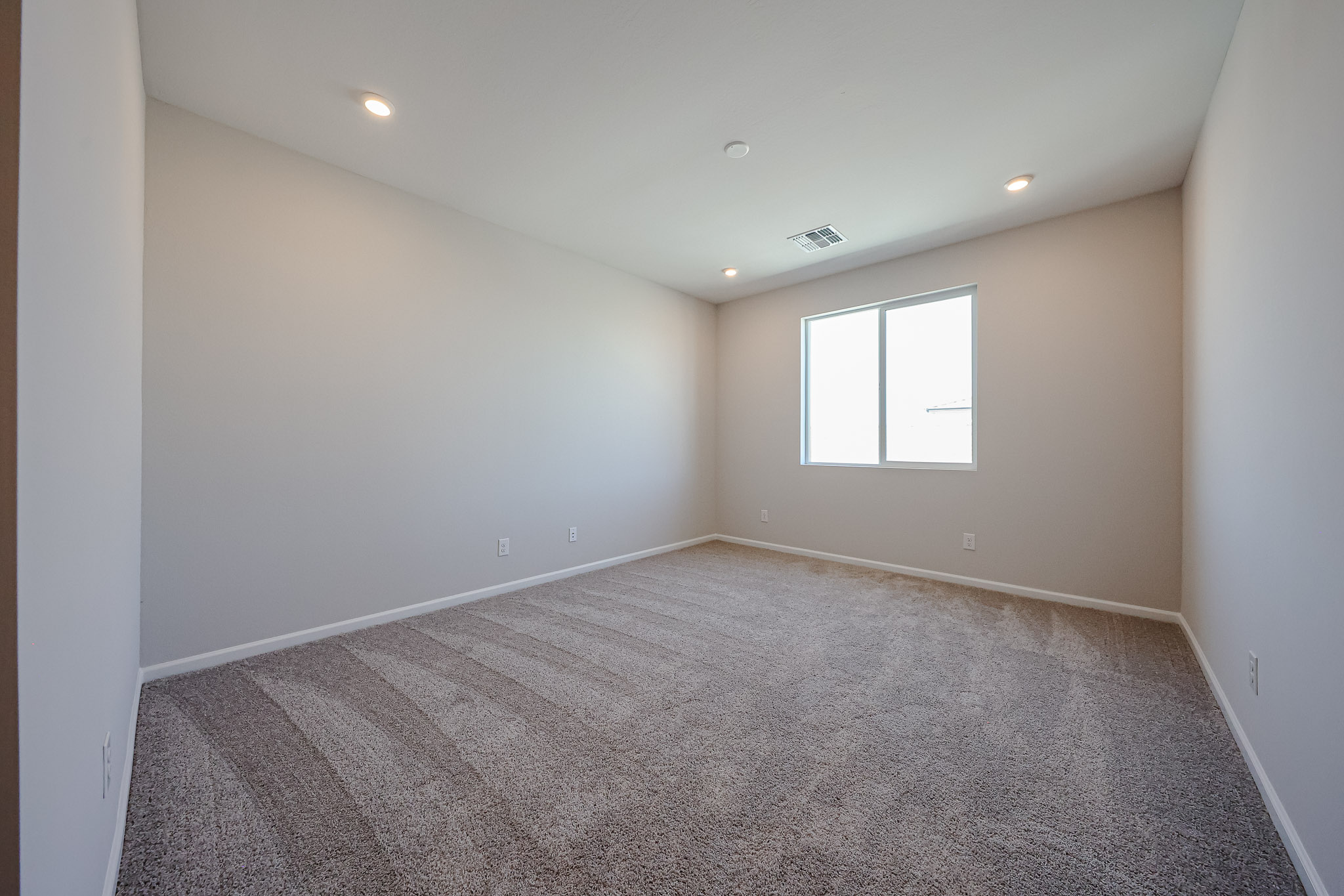 A room with a carpet and windows.