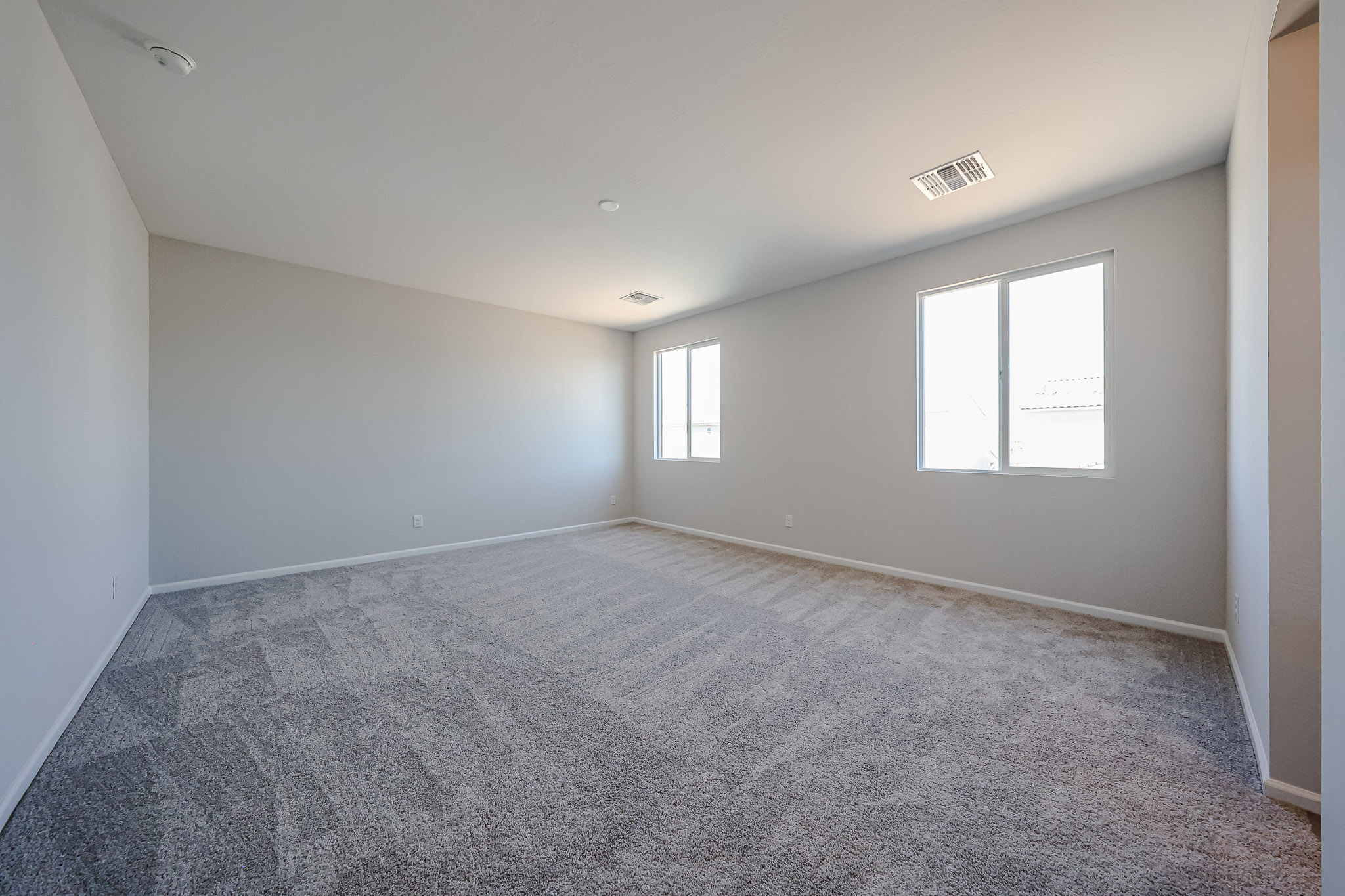 A room with a carpet and windows.