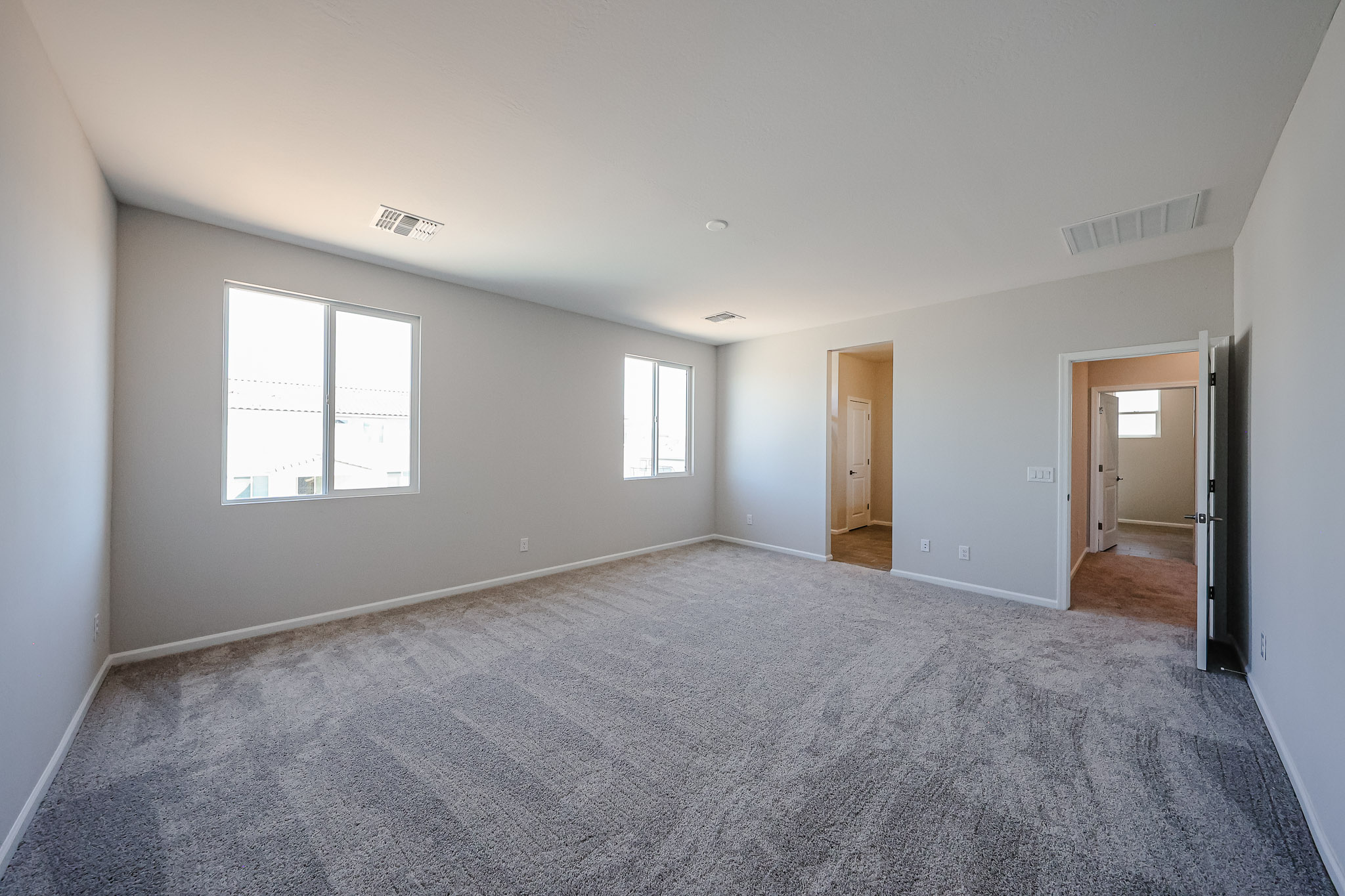A room with a carpet and windows.
