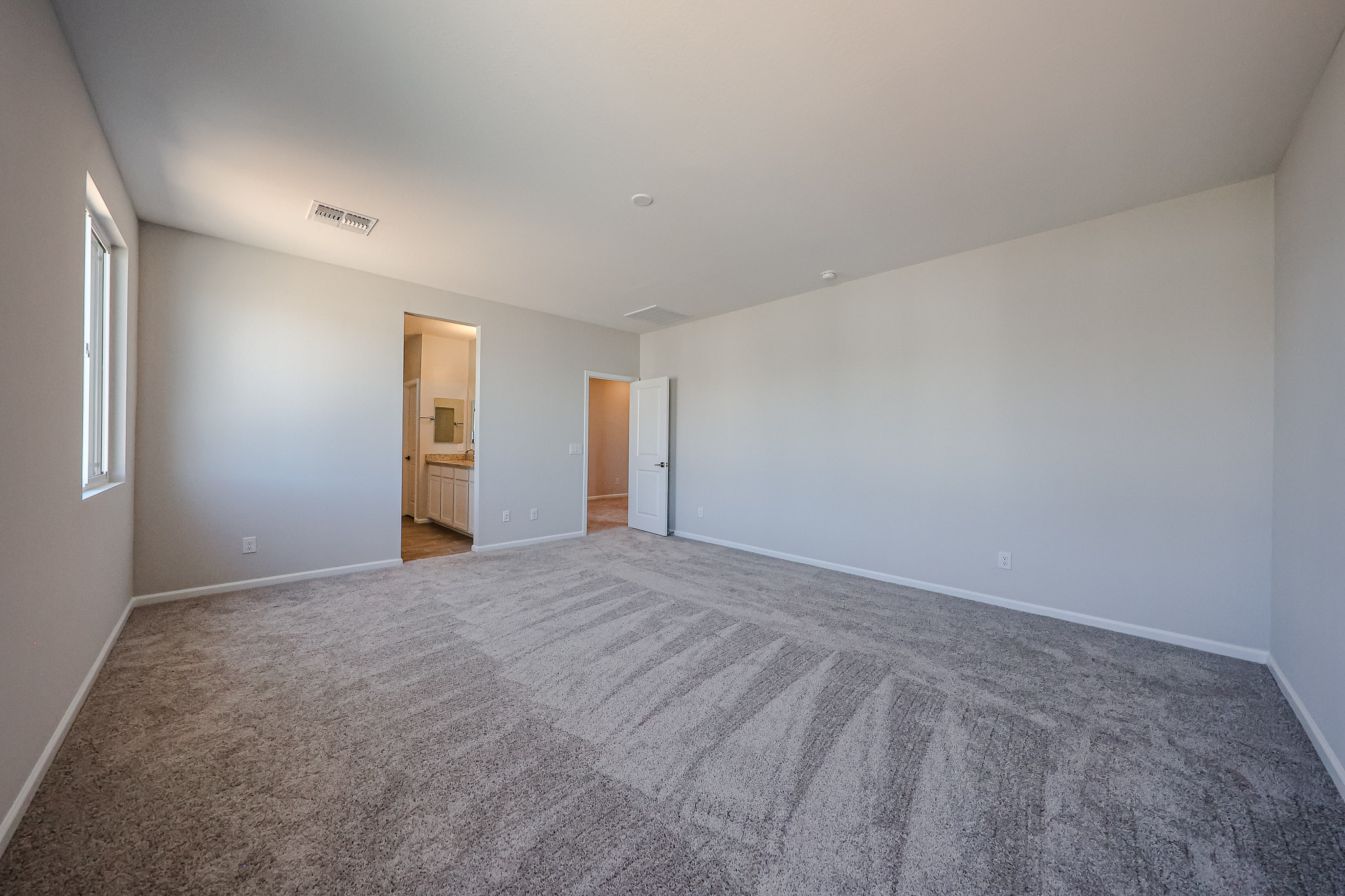 A room with a carpet and a door.