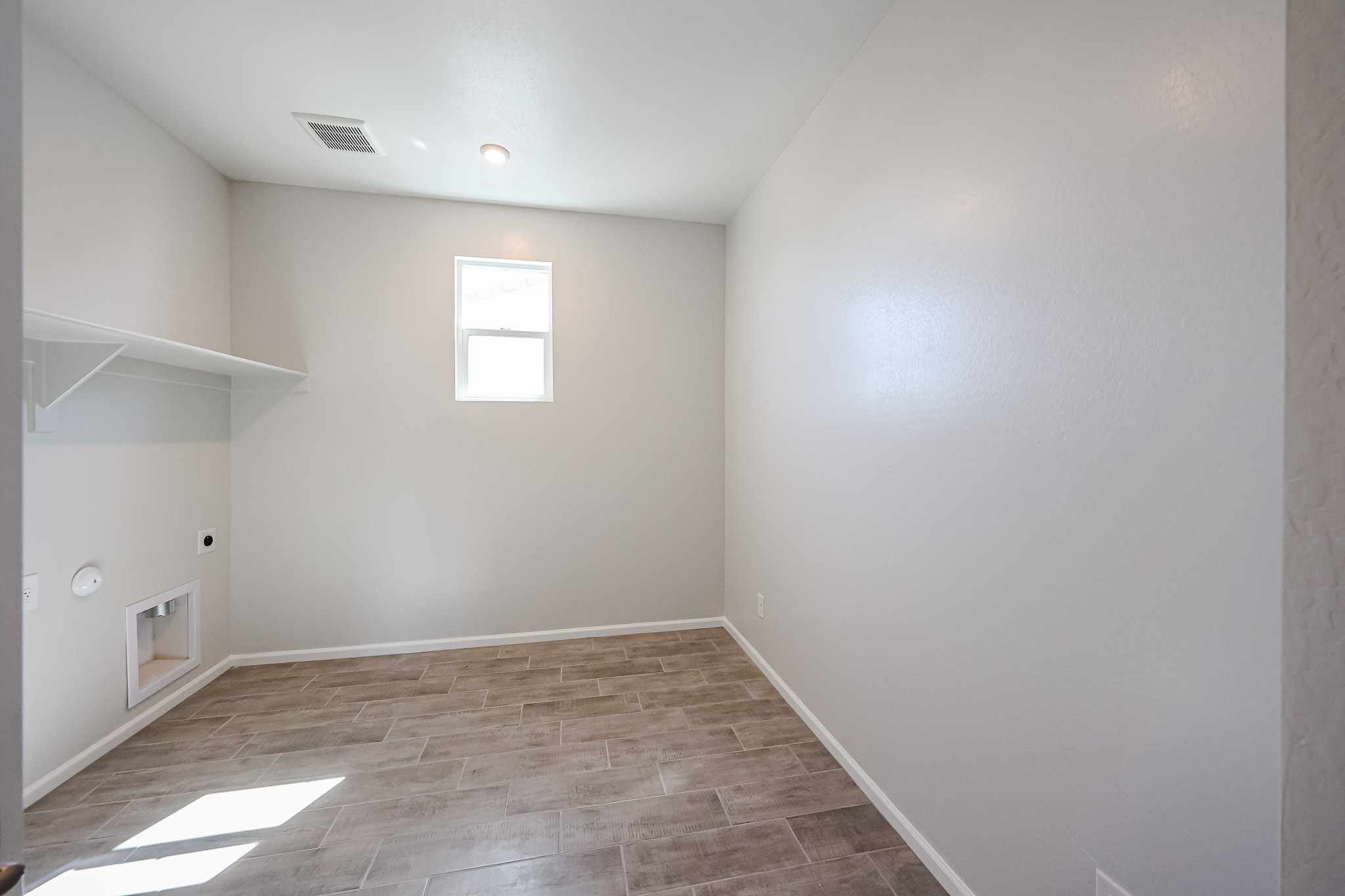 A room with a wood floor and white walls.