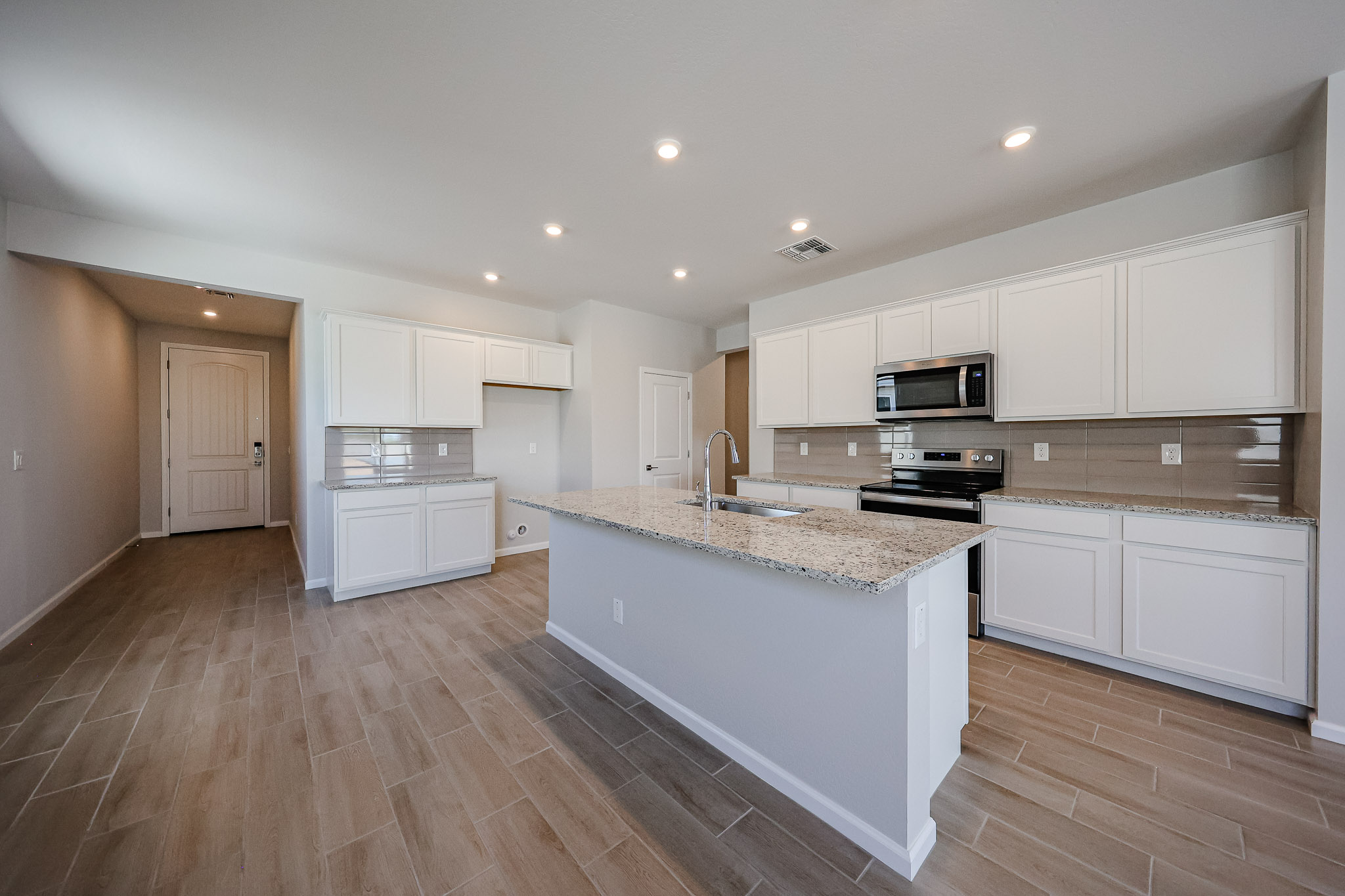 A kitchen with white cabinets.