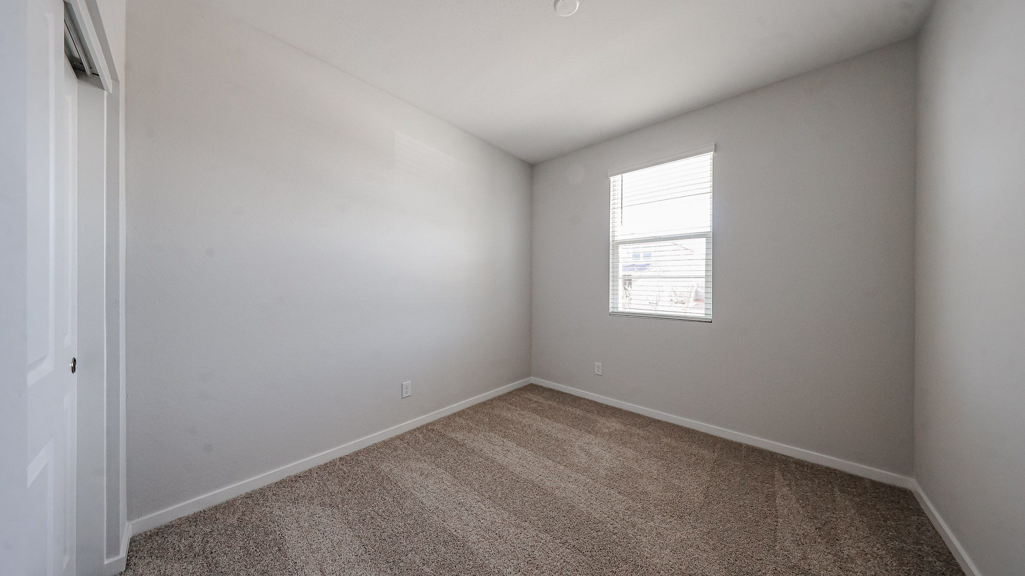 A room with a carpet and a window.