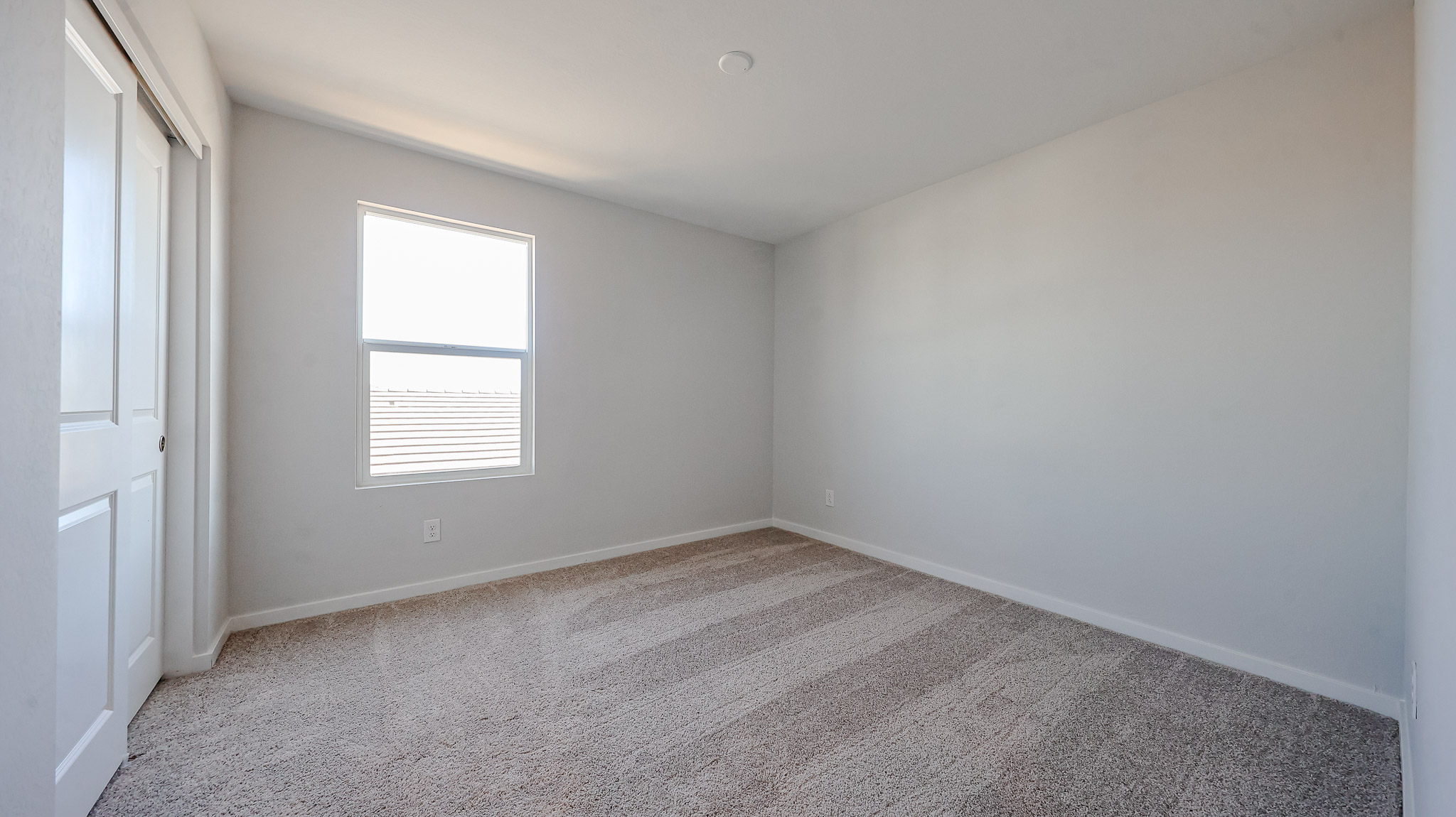 A room with a carpet and a window.
