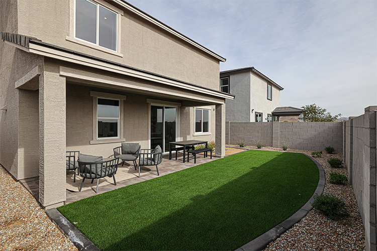 A backyard with a pool and chairs.