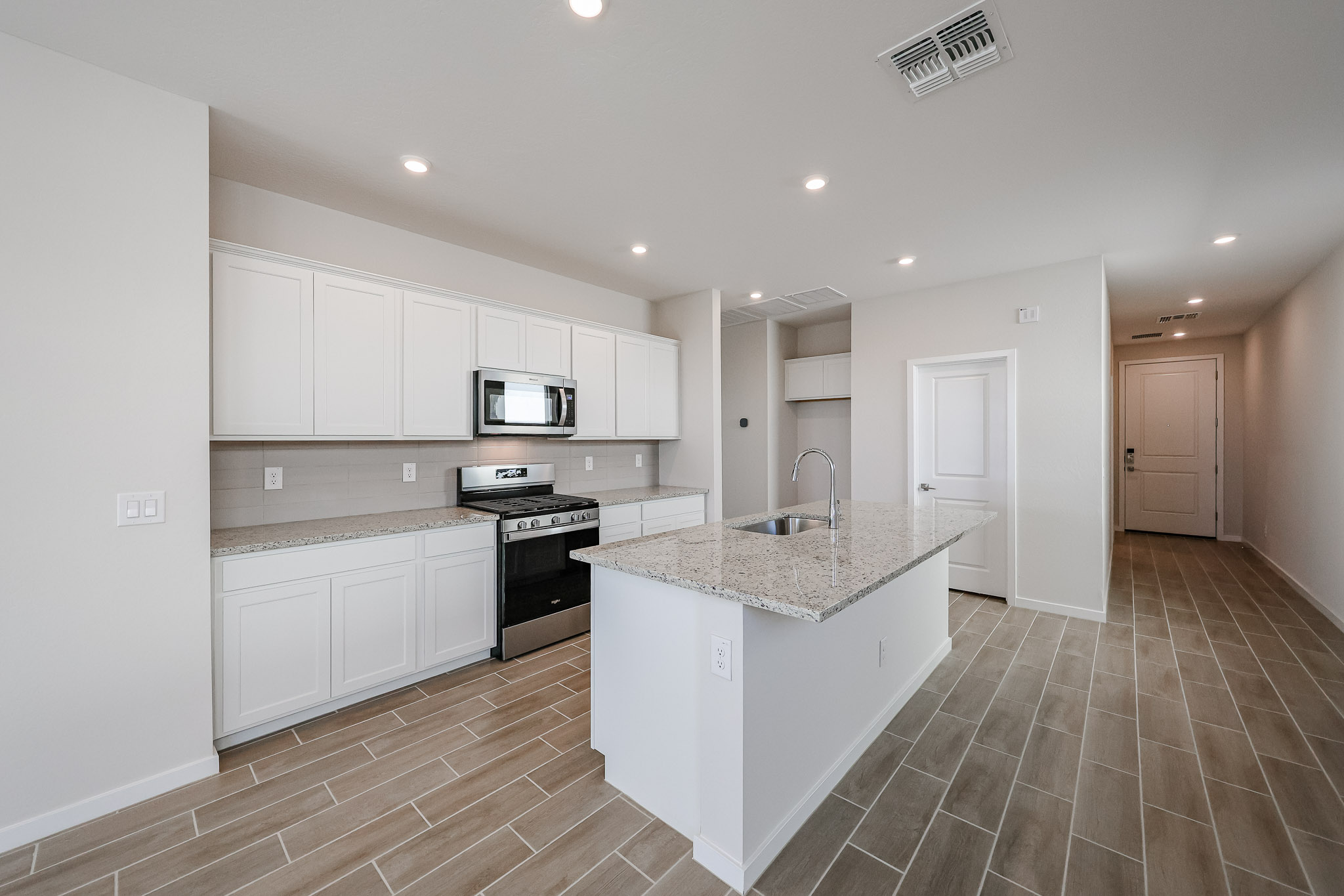 A kitchen with white cabinets.