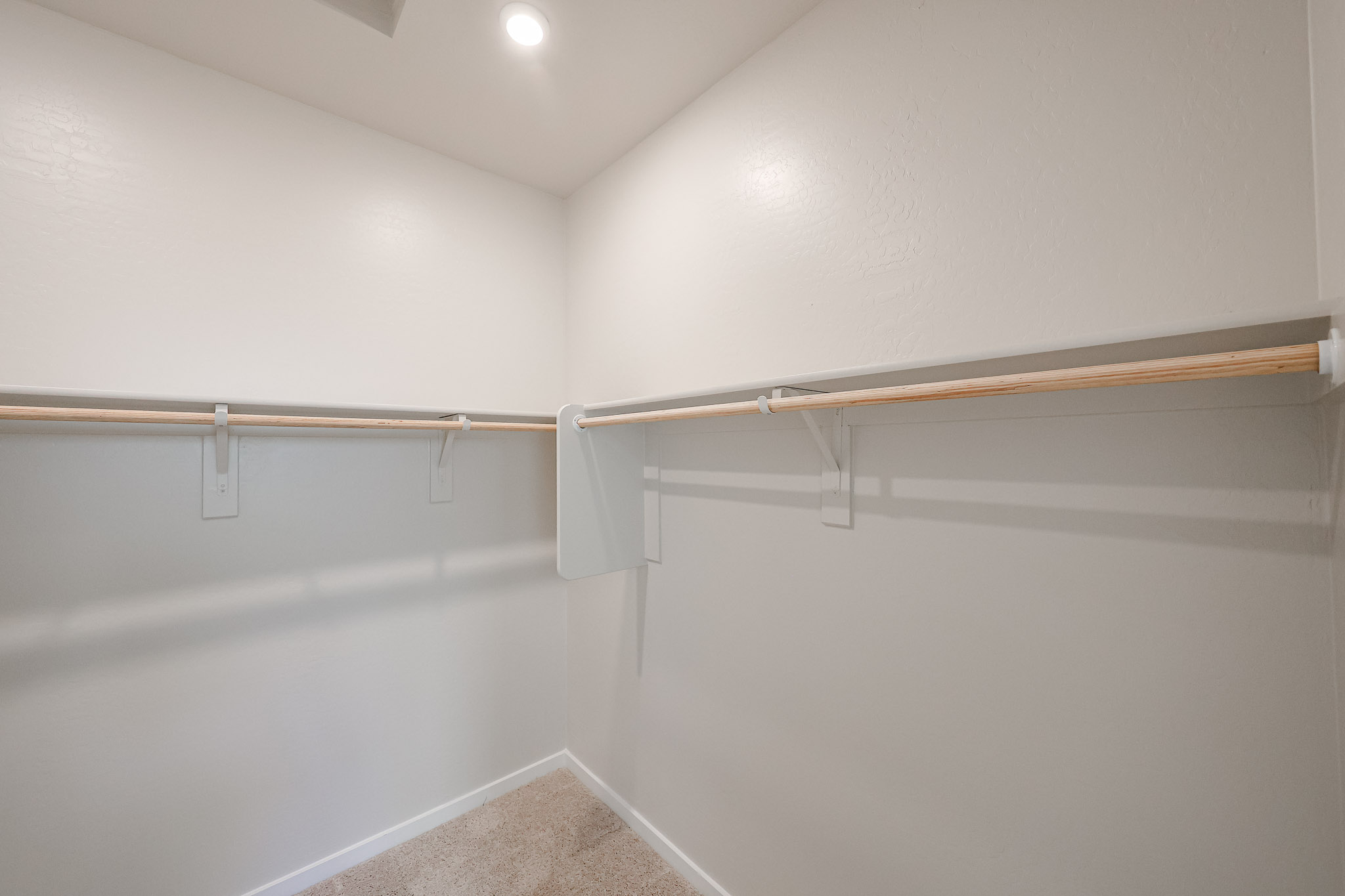 A white wall with a metal bar.