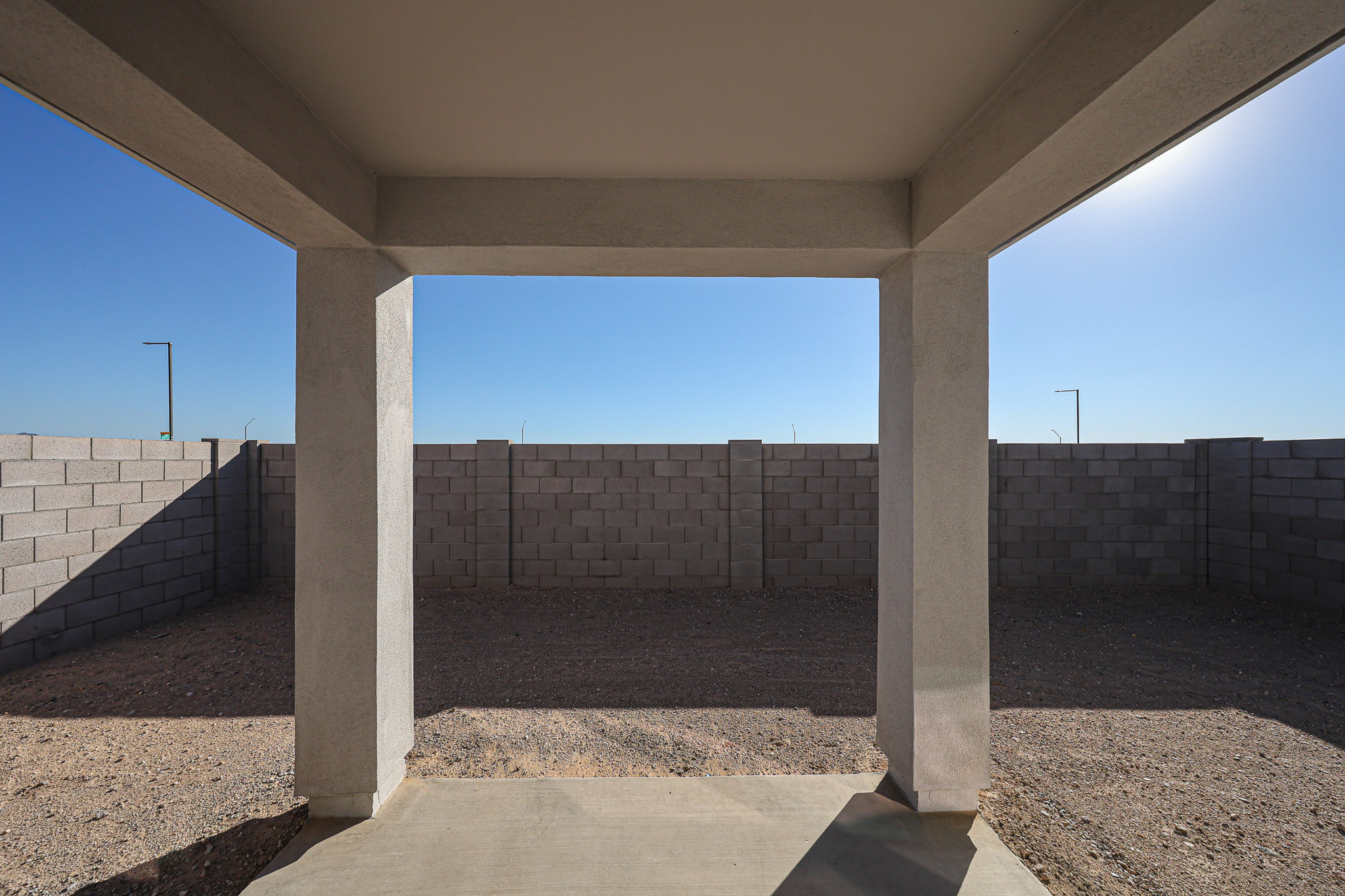 A concrete walkway with pillars.