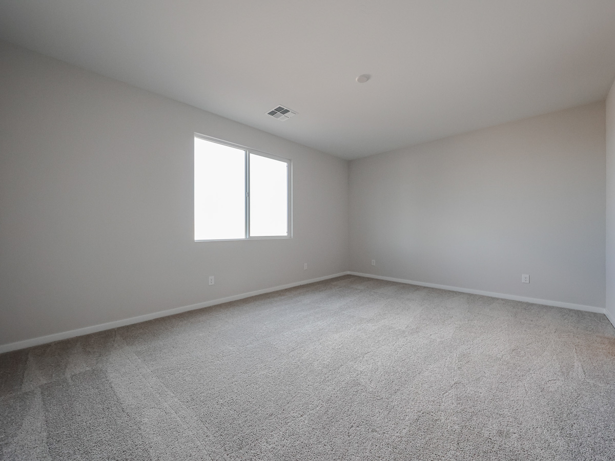 A room with a window and a carpet.