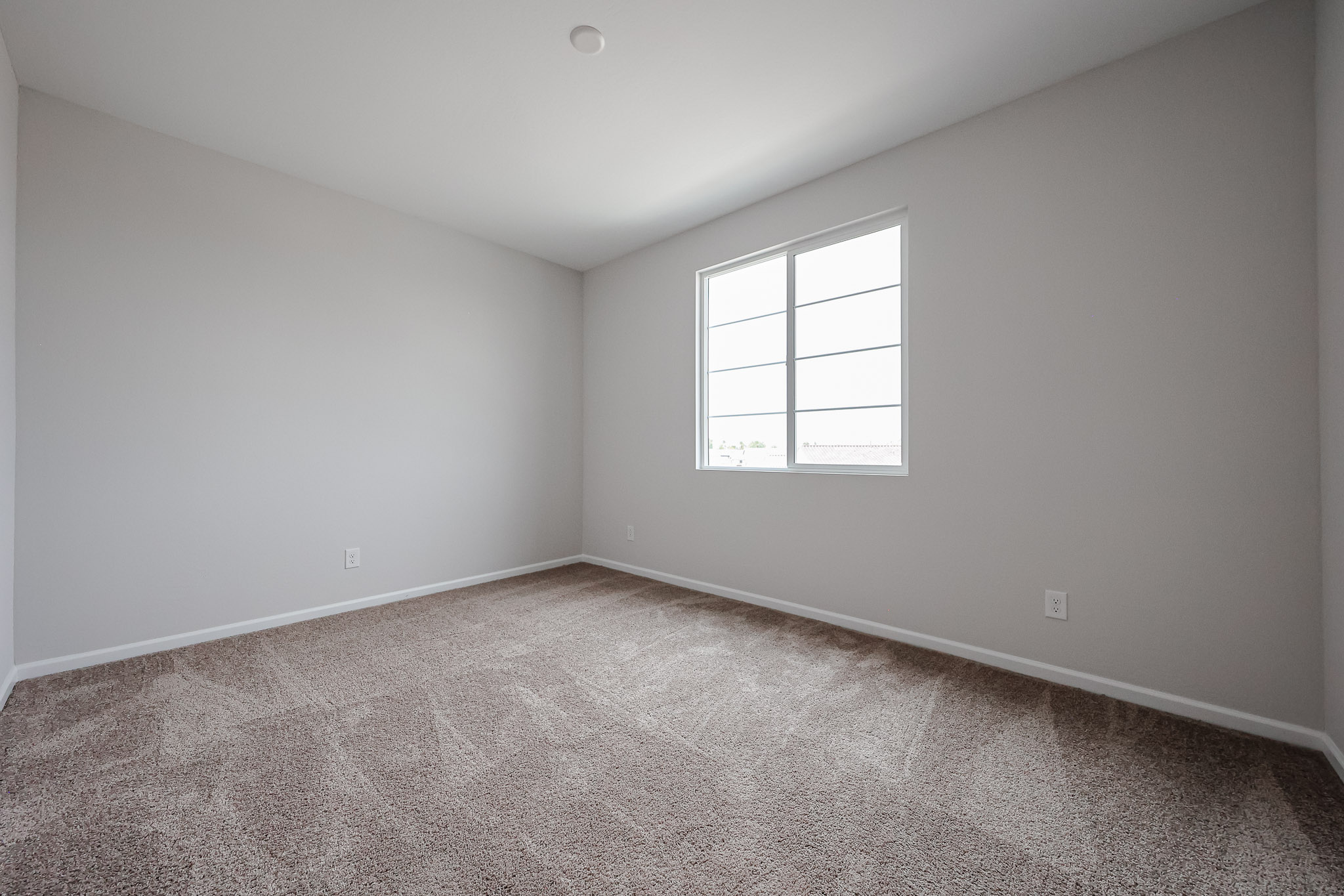 A room with a window and carpet.