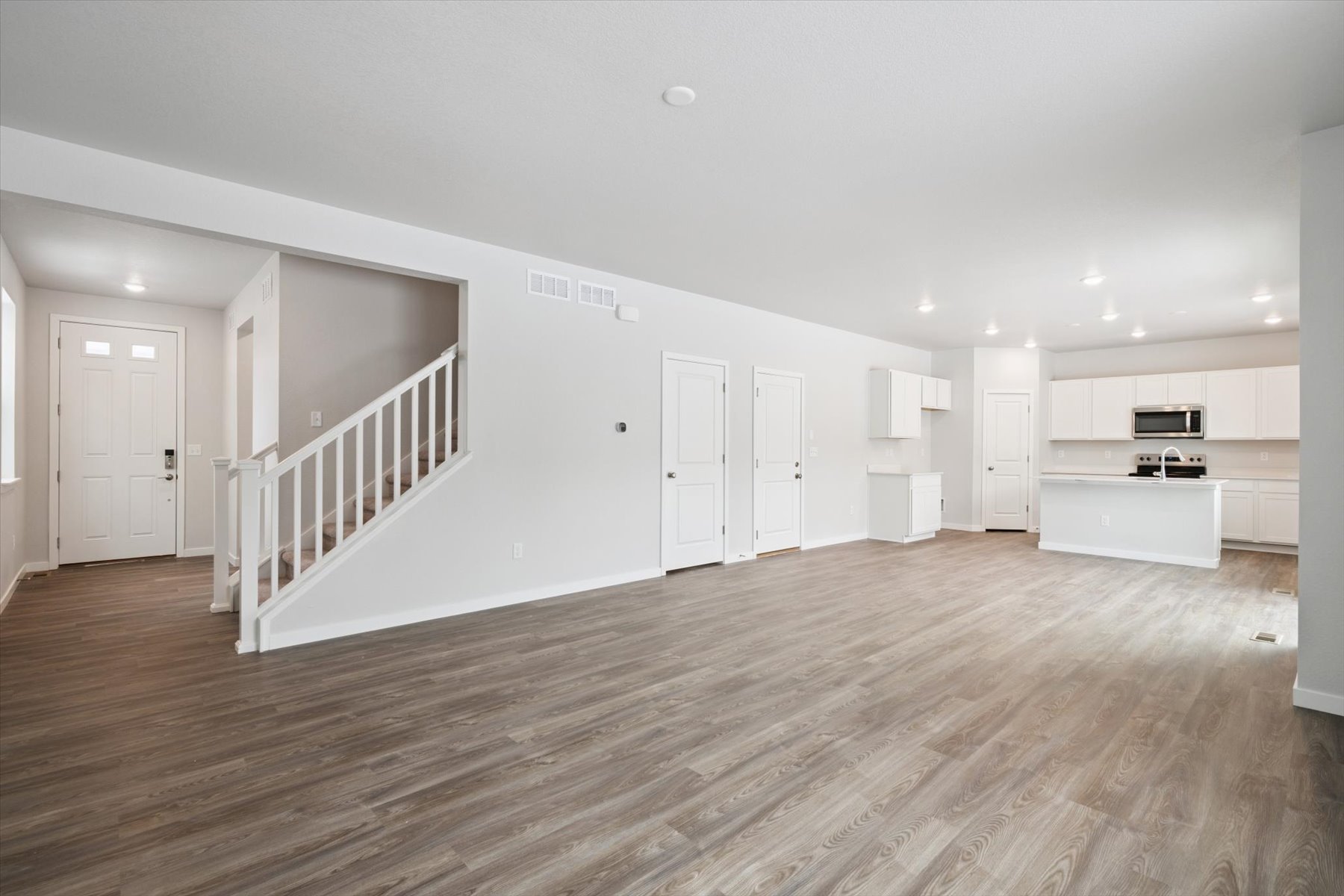 A large empty room with white doors.