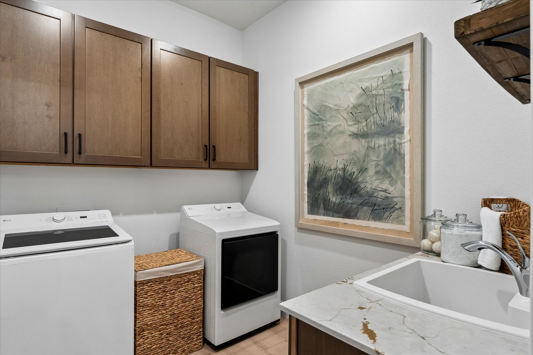 A kitchen with a painting on the wall.
