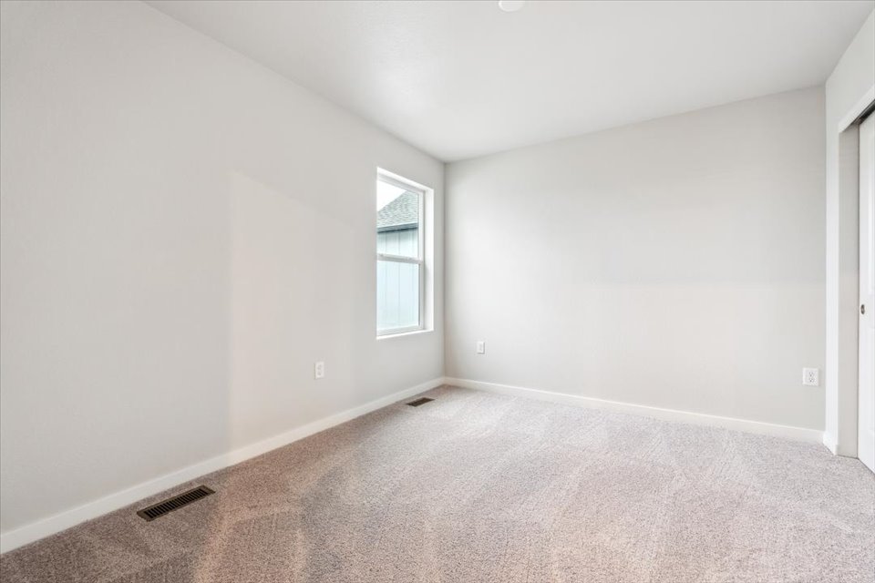 A room with a carpet and a window.