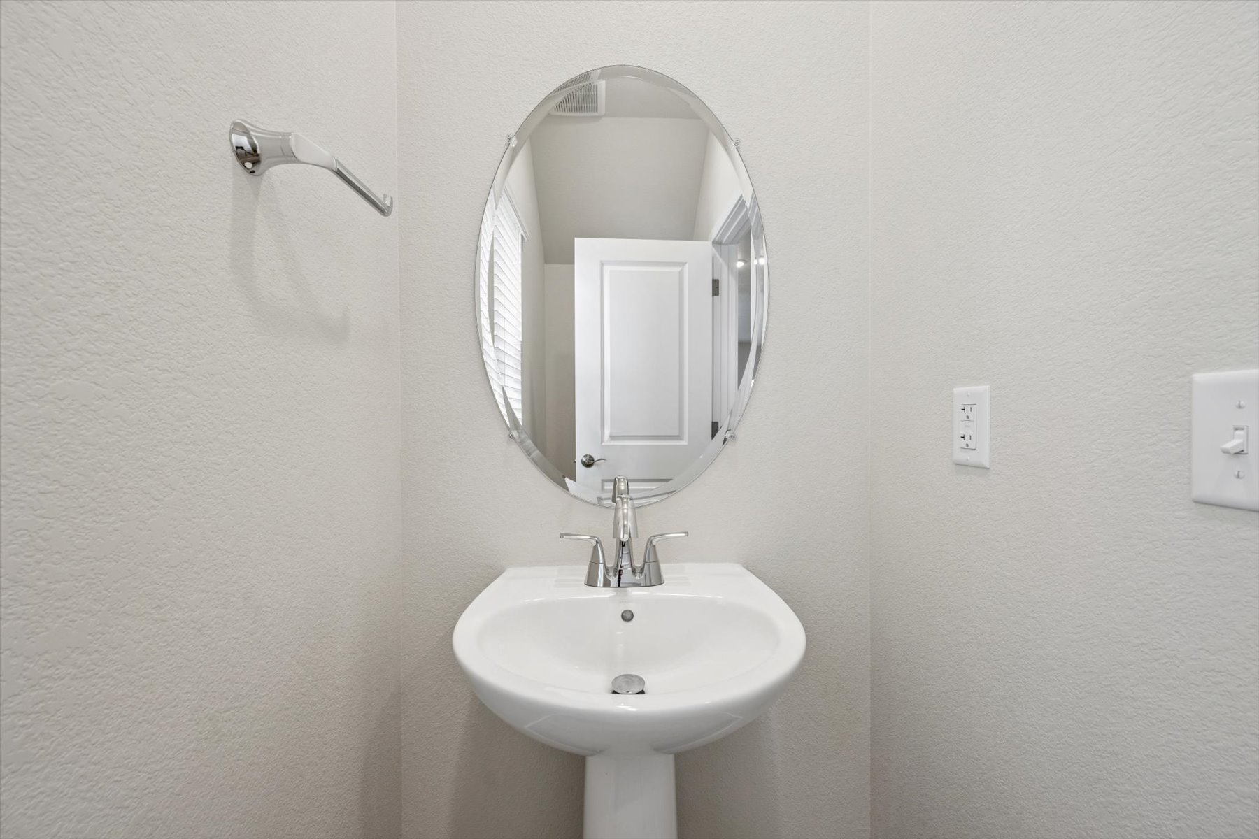 A bathroom with a round mirror.