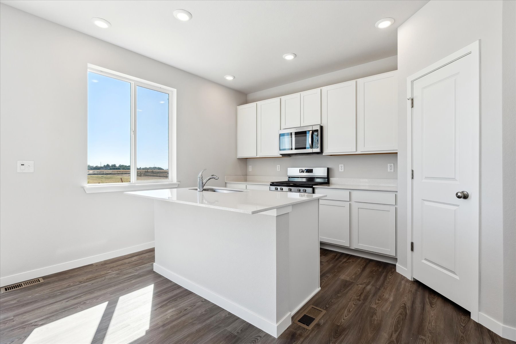 A kitchen with white cabinets.