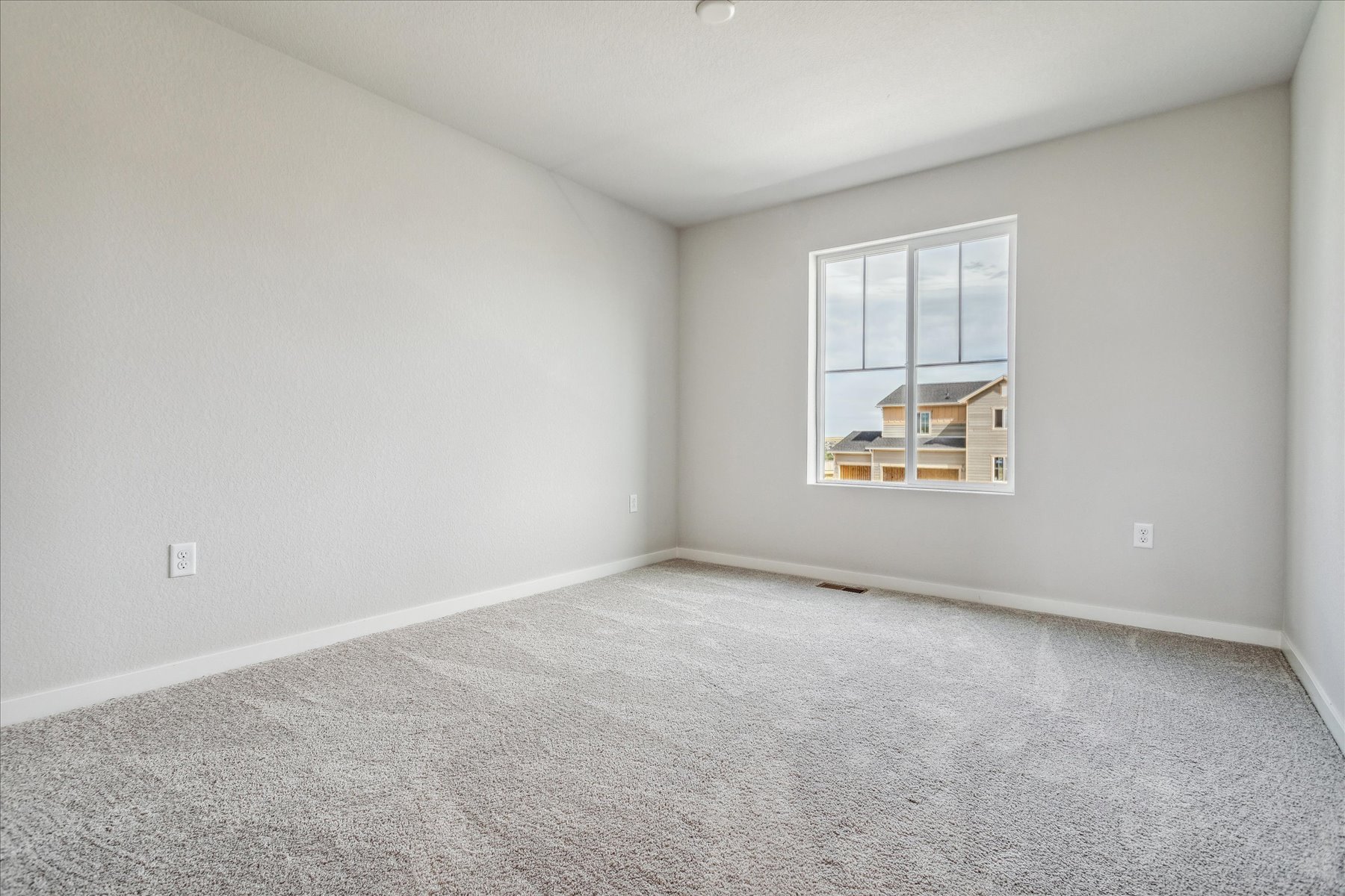 A room with a window and a carpet.