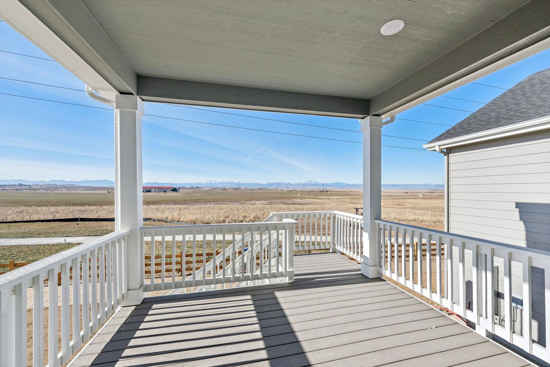 A deck with a railing and a view of a desert.