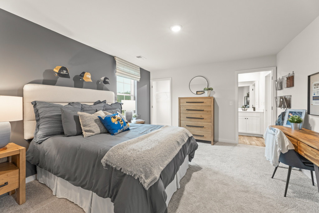 A bedroom with a bed and a desk.