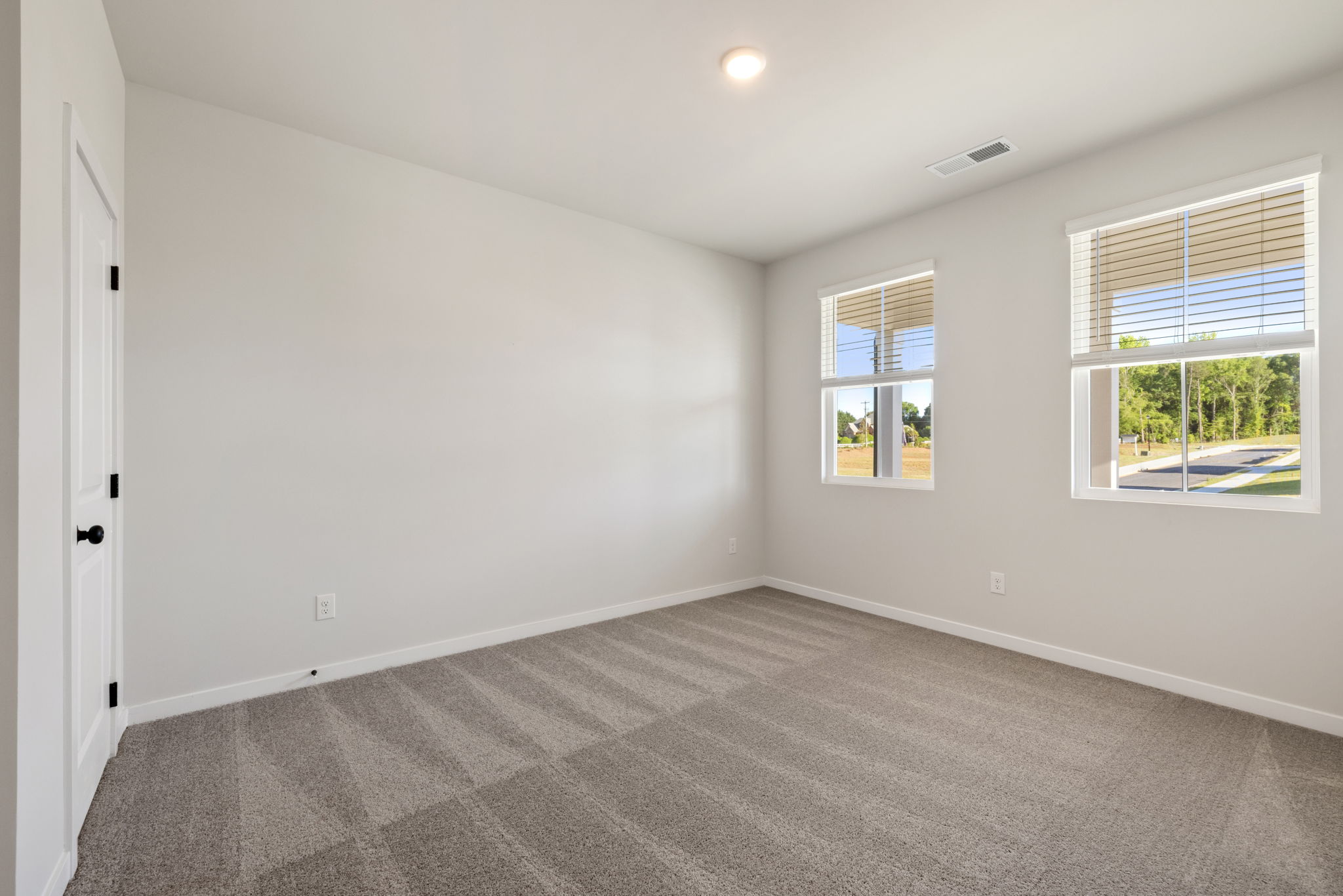 A room with windows and a carpet.