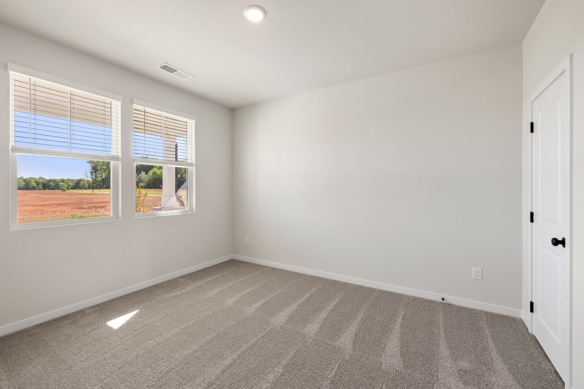 A room with a window and a carpet.