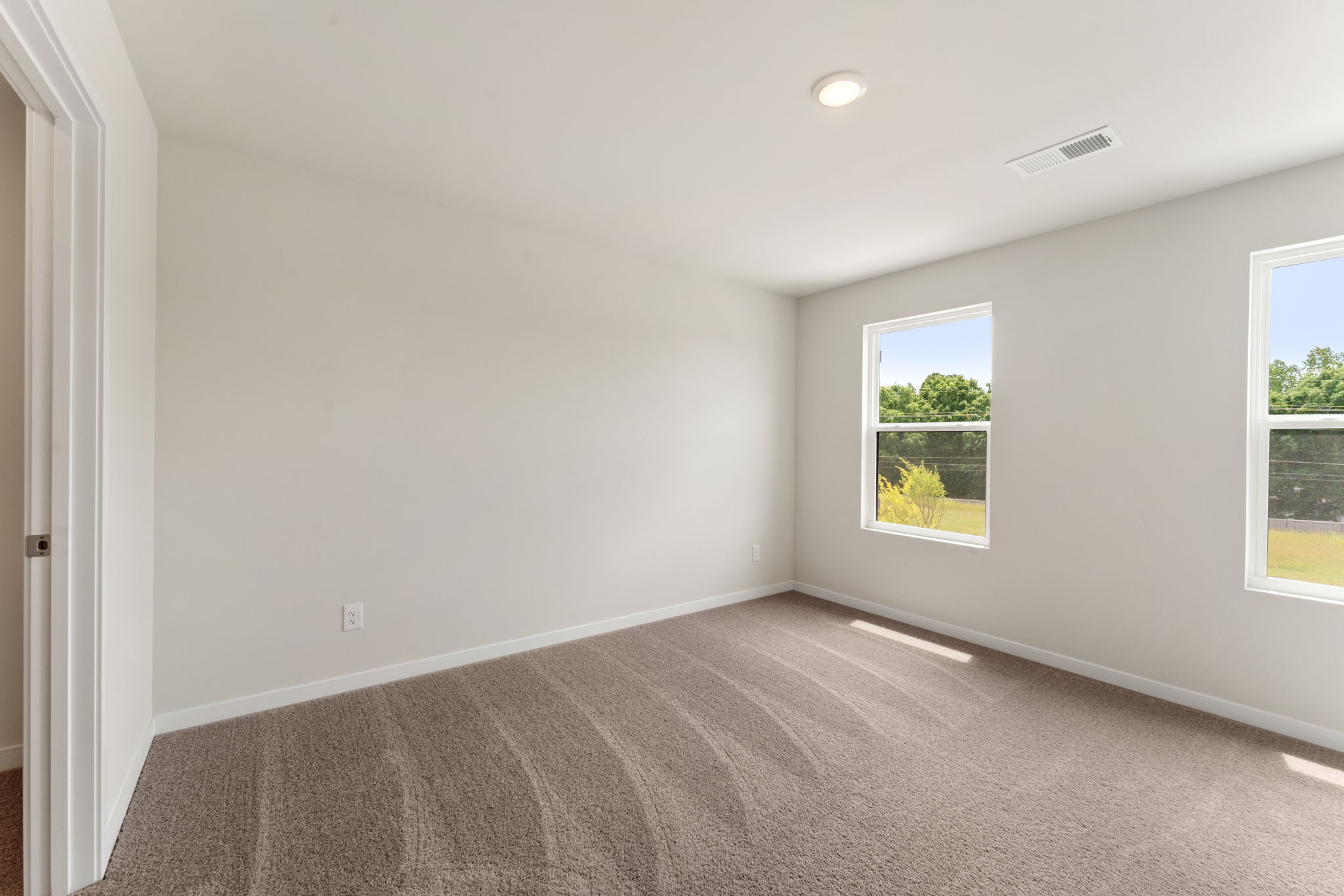 A room with a carpet and windows.