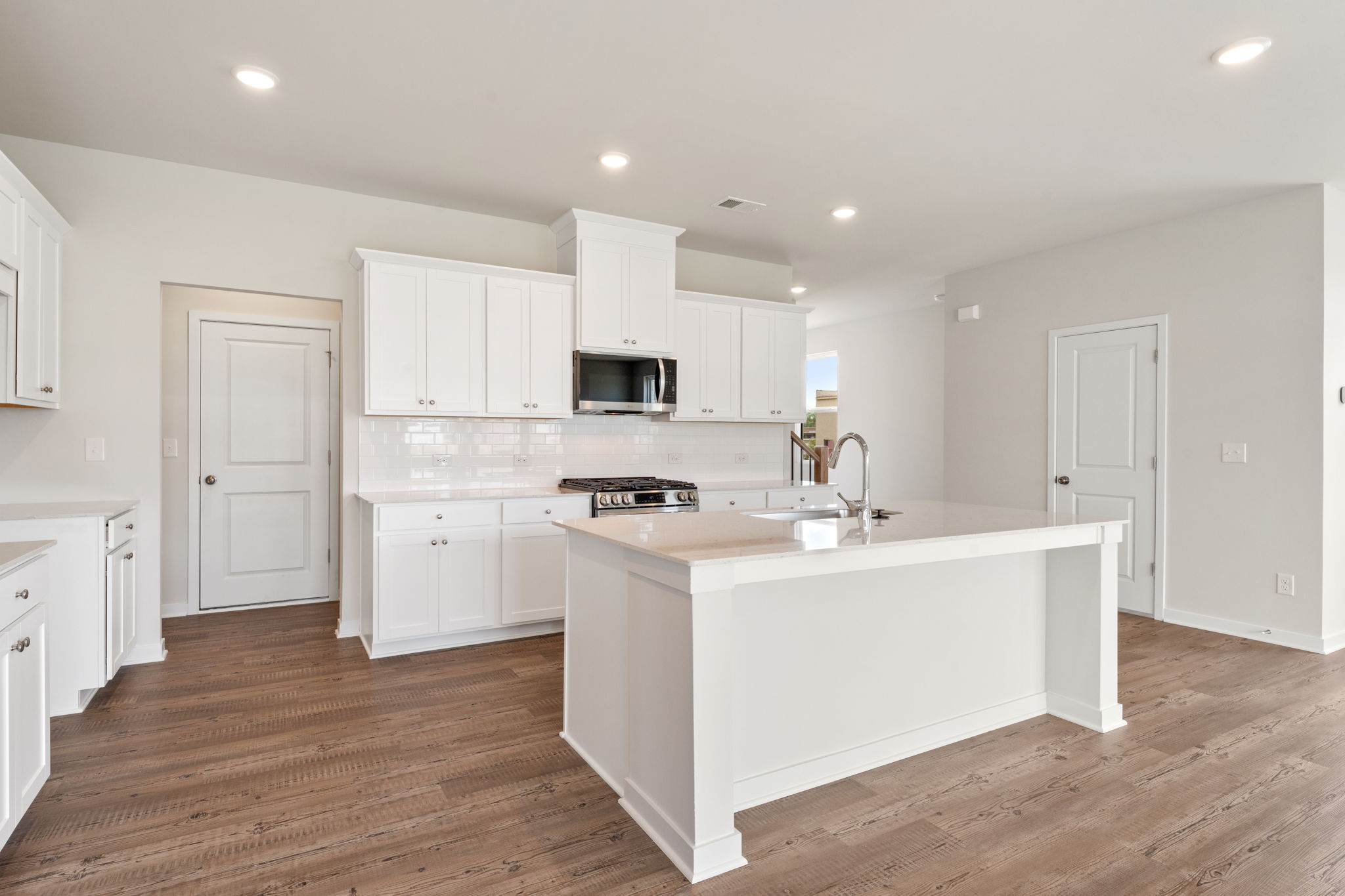 A kitchen with white cabinets.