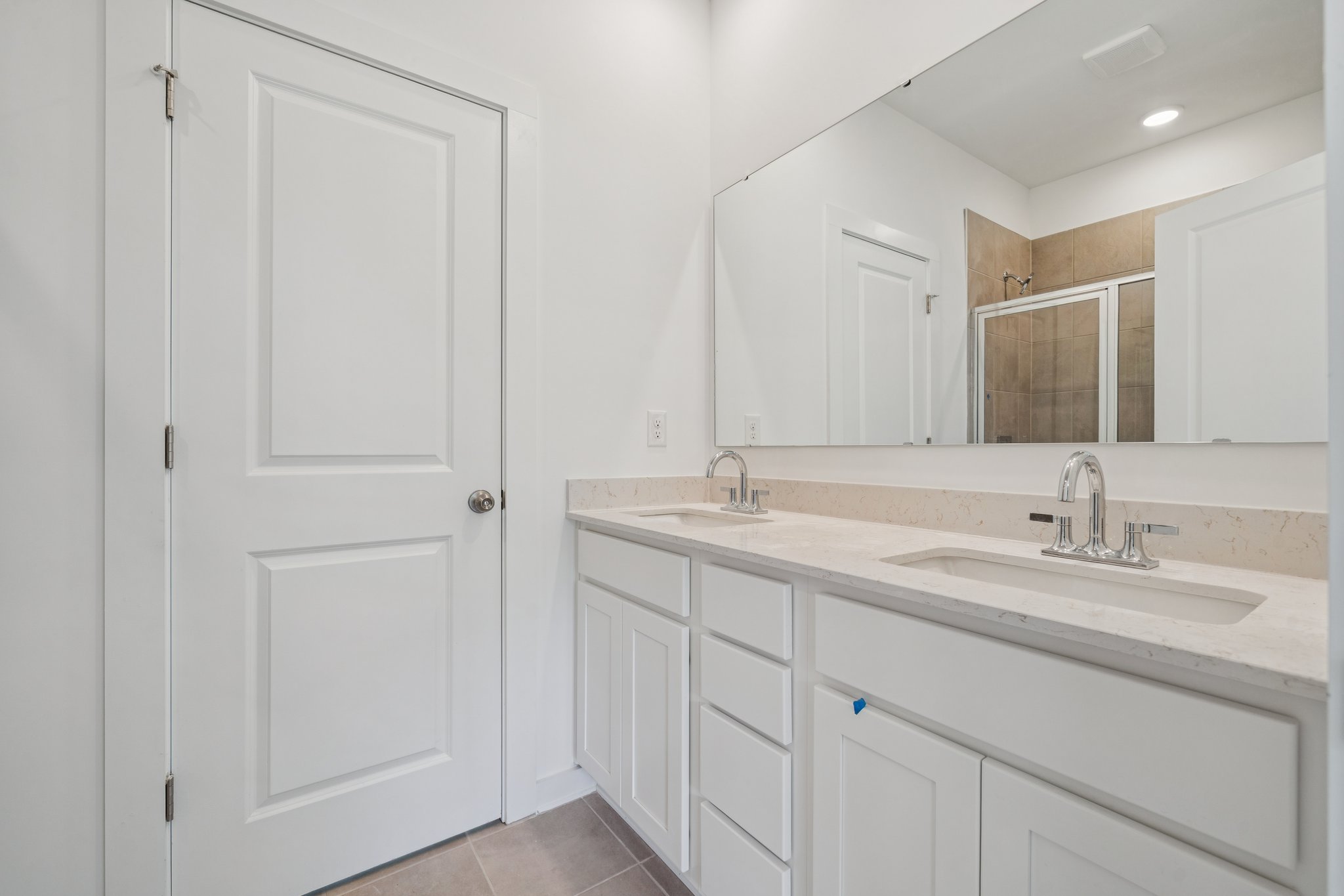 A bathroom with white cabinets.