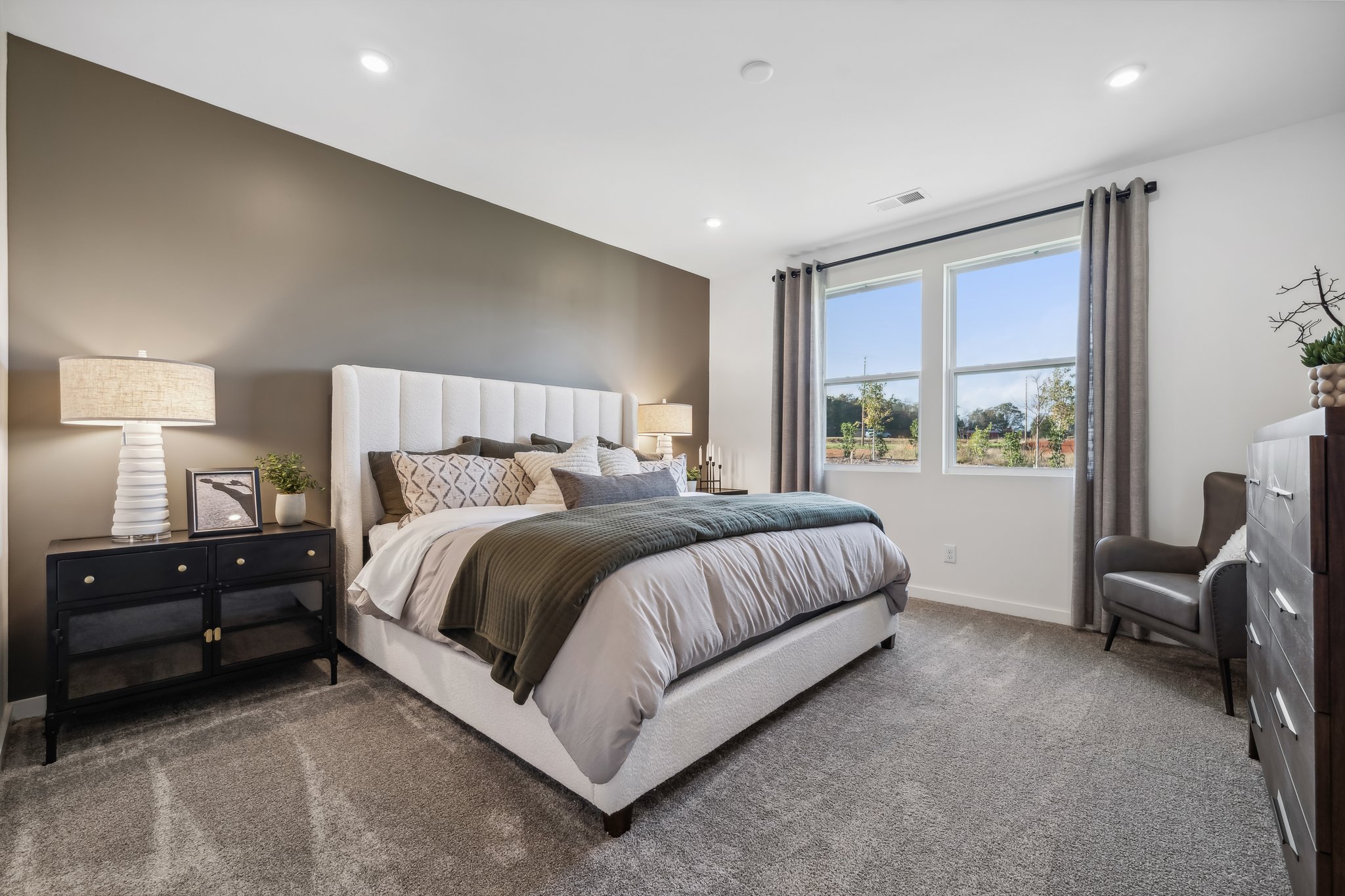 A bedroom with a bed and a chair.