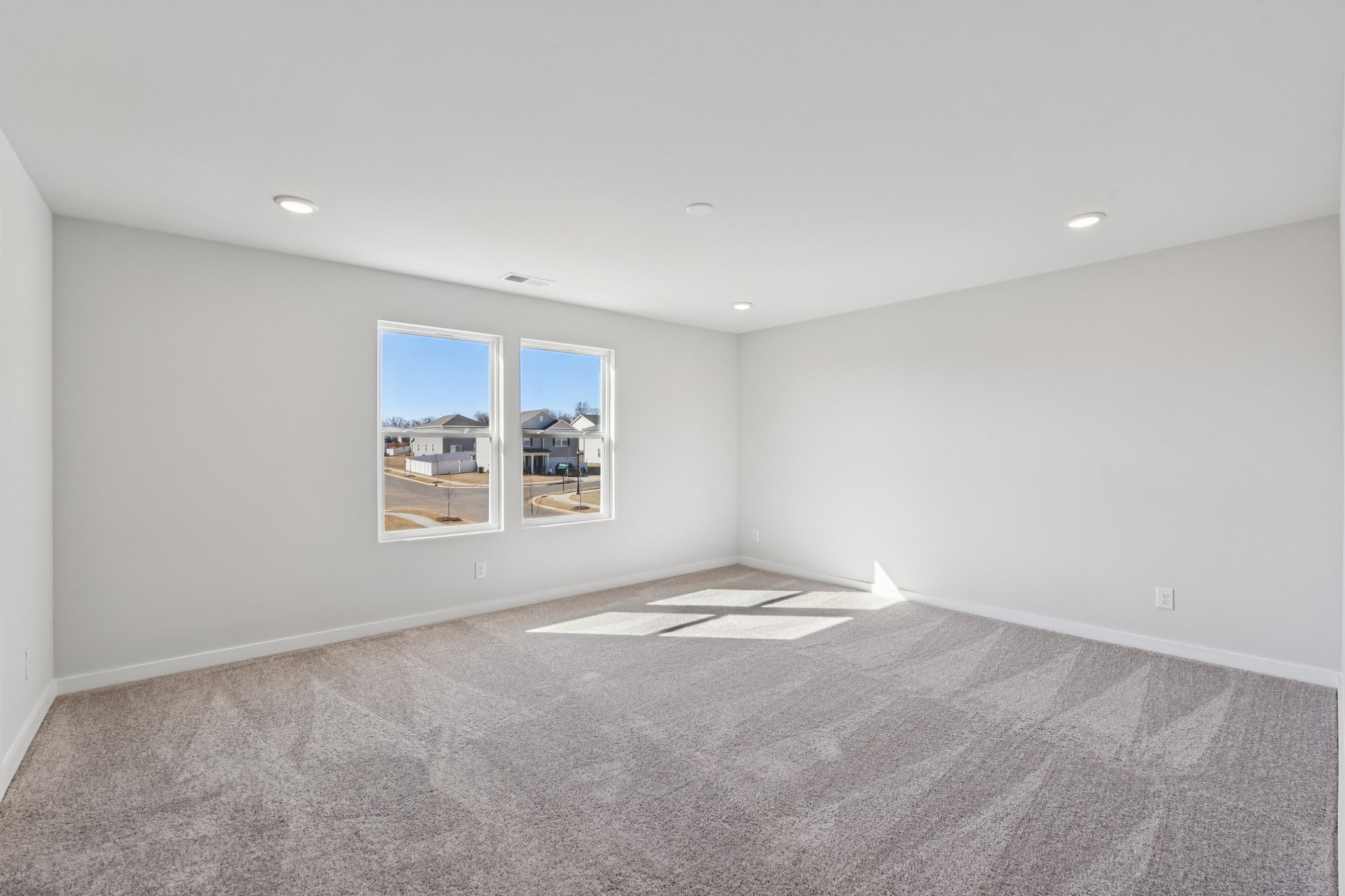A room with a window and a rug.