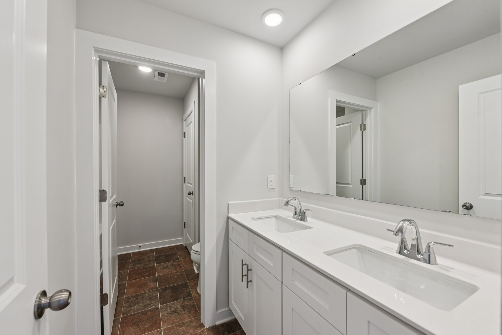 A bathroom with a large mirror.