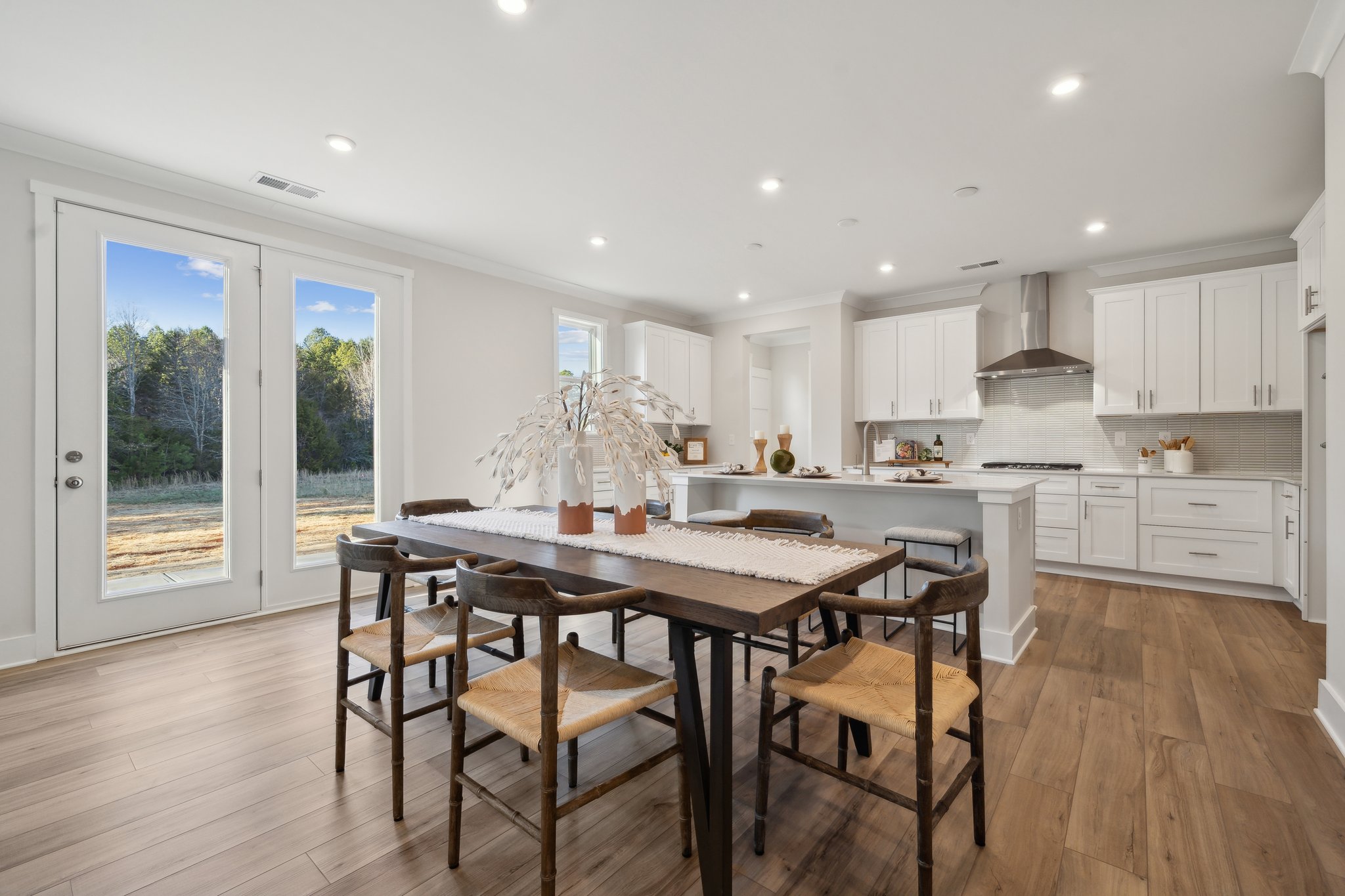 A kitchen with a dining table and chairs.