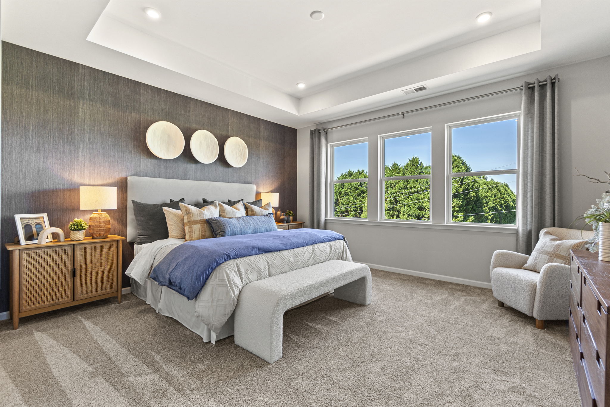 A bedroom with a bed and a chair.