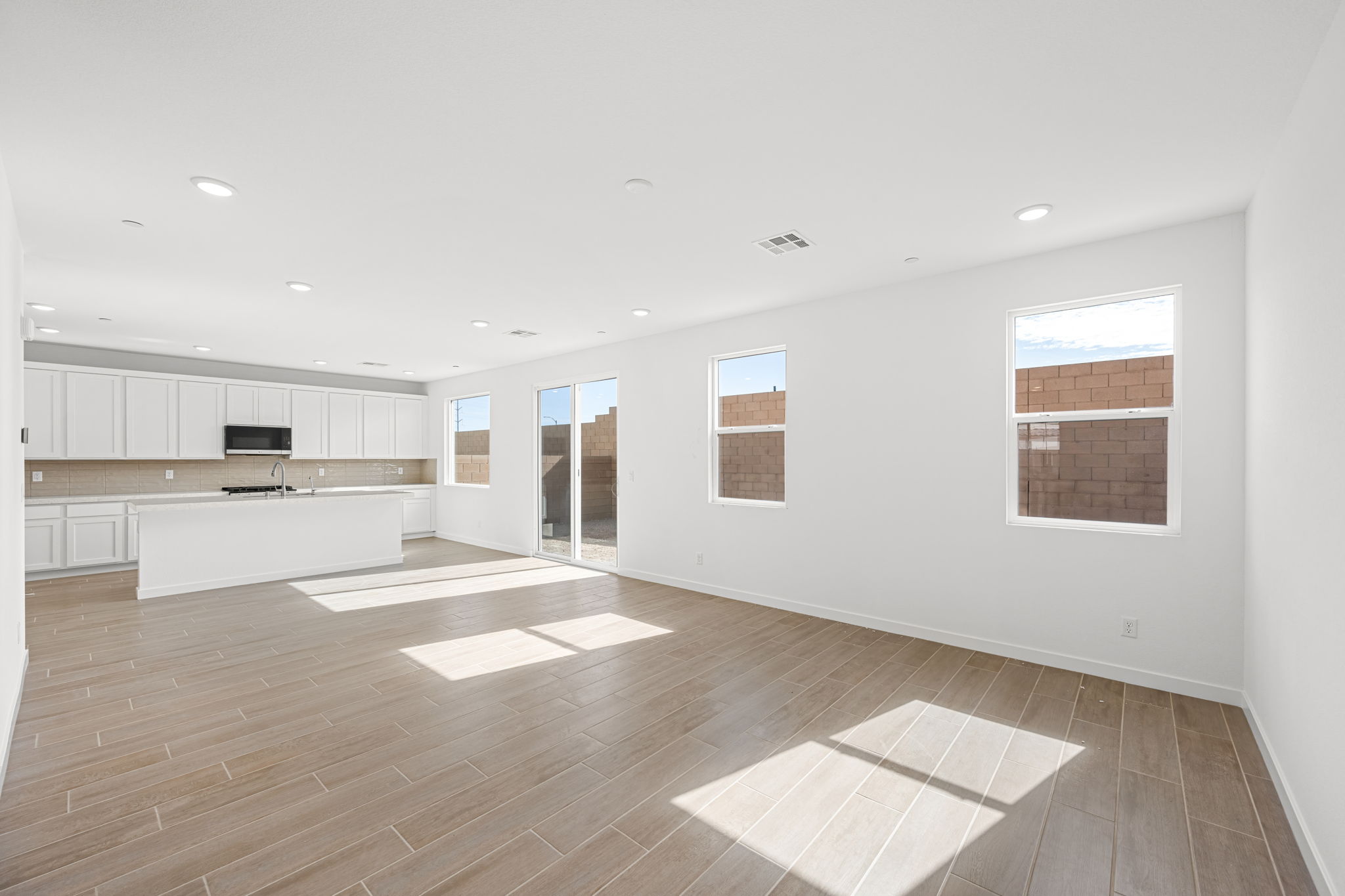 A large empty room with a wood floor and white walls.