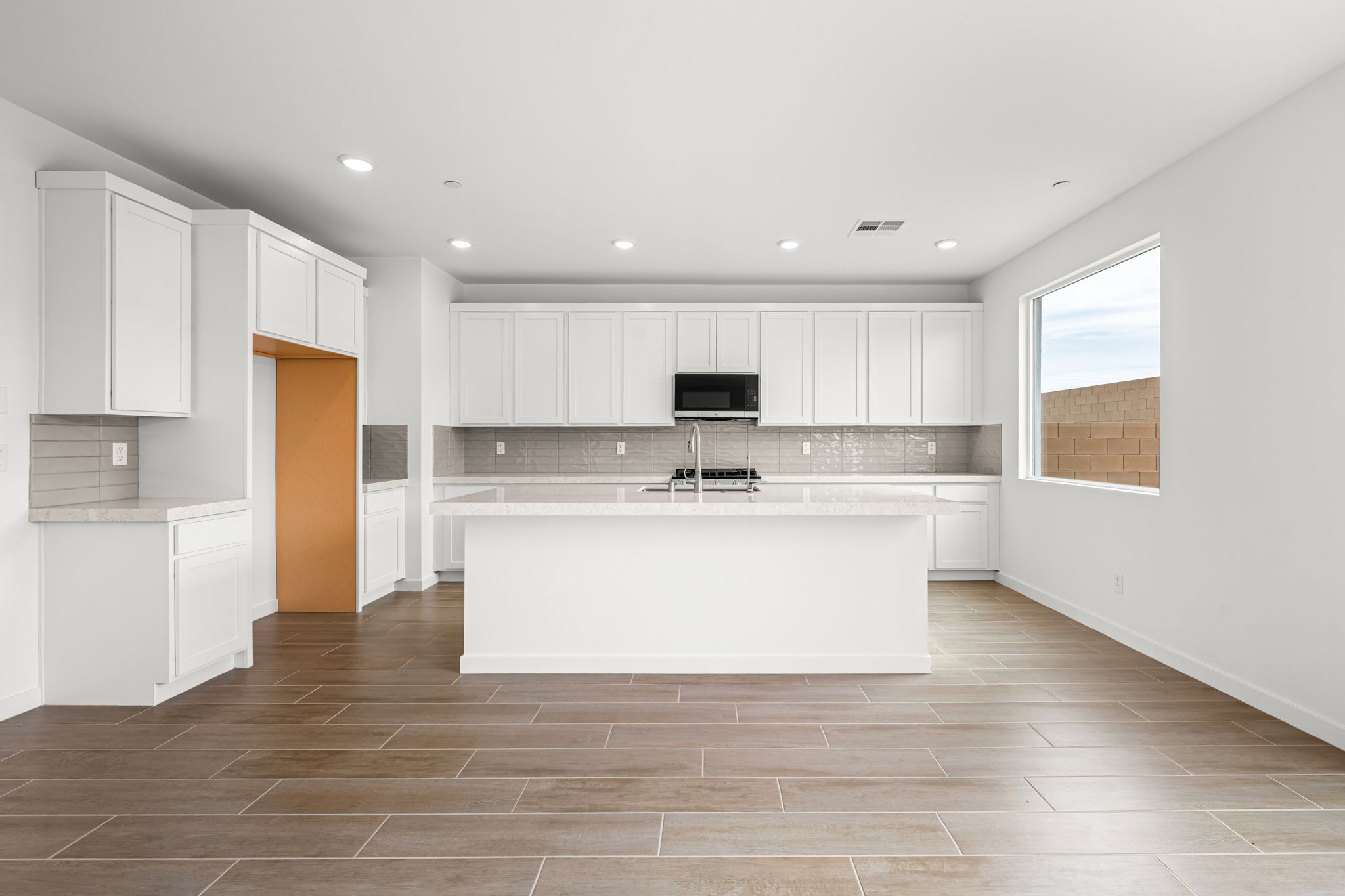 A kitchen with white cabinets.