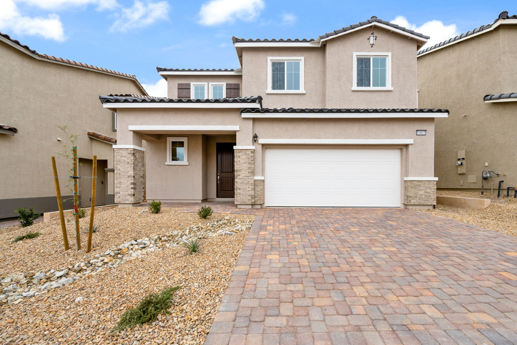 A brick driveway leading to a house.