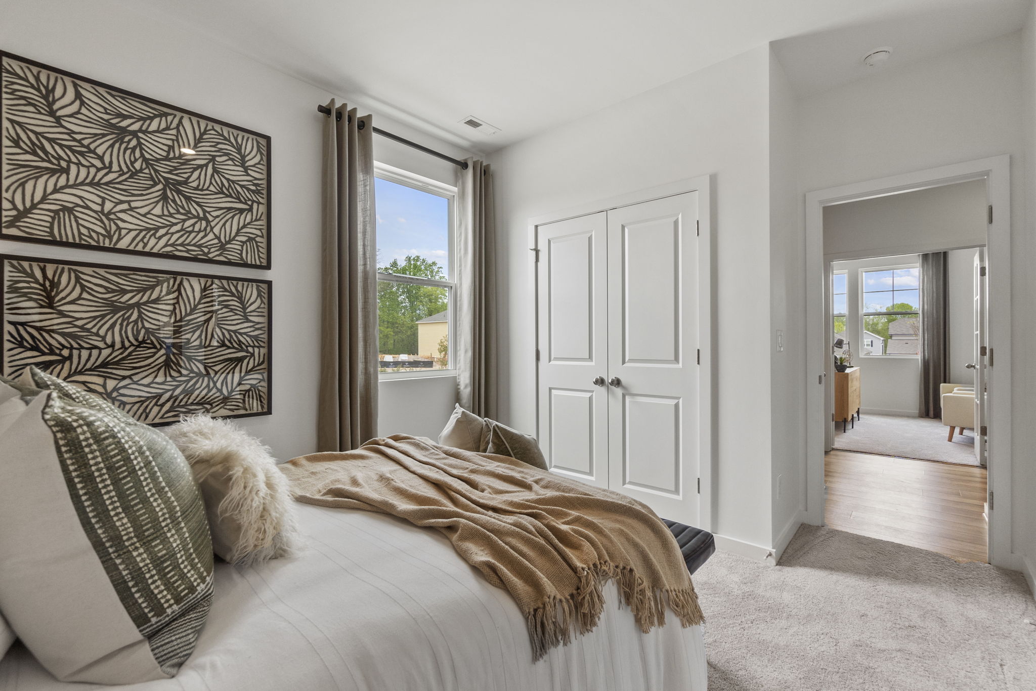 A bedroom with a bed and a large window.