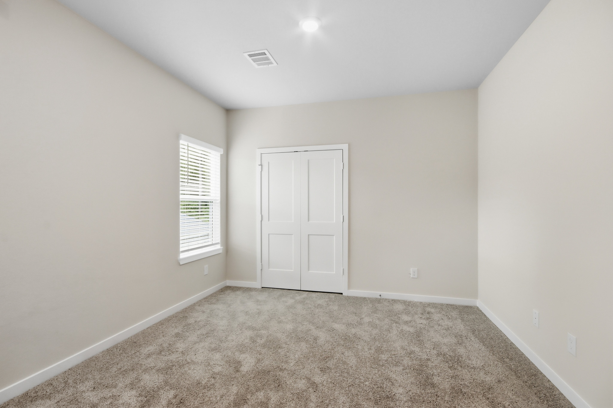 A room with a carpet and a door.