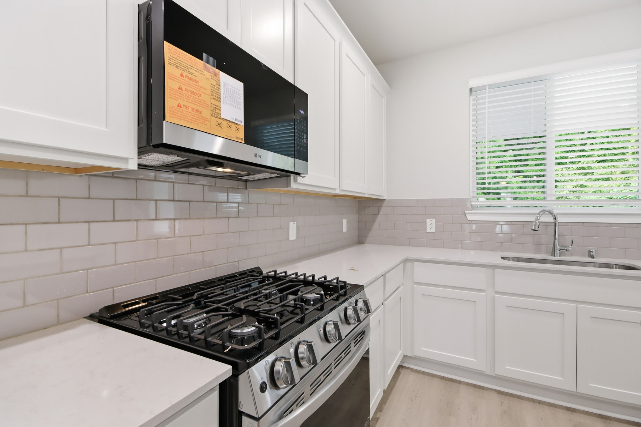 A kitchen with white cabinets.