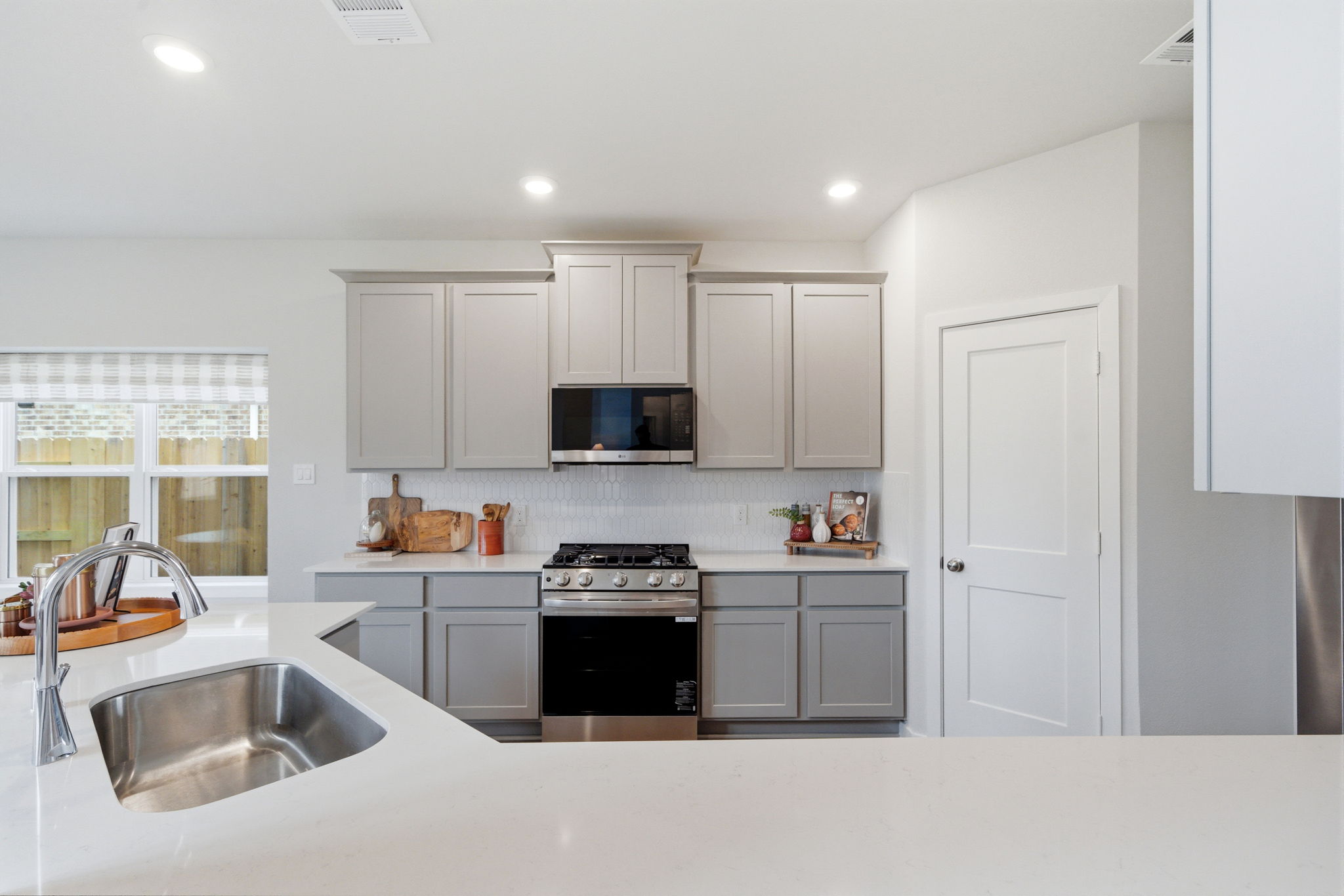A kitchen with white cabinets.