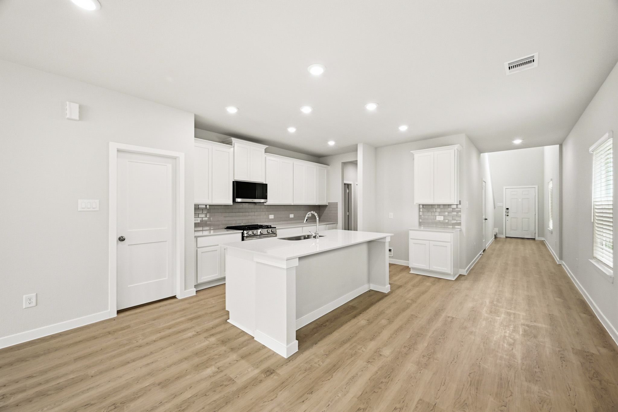 A kitchen with white cabinets.