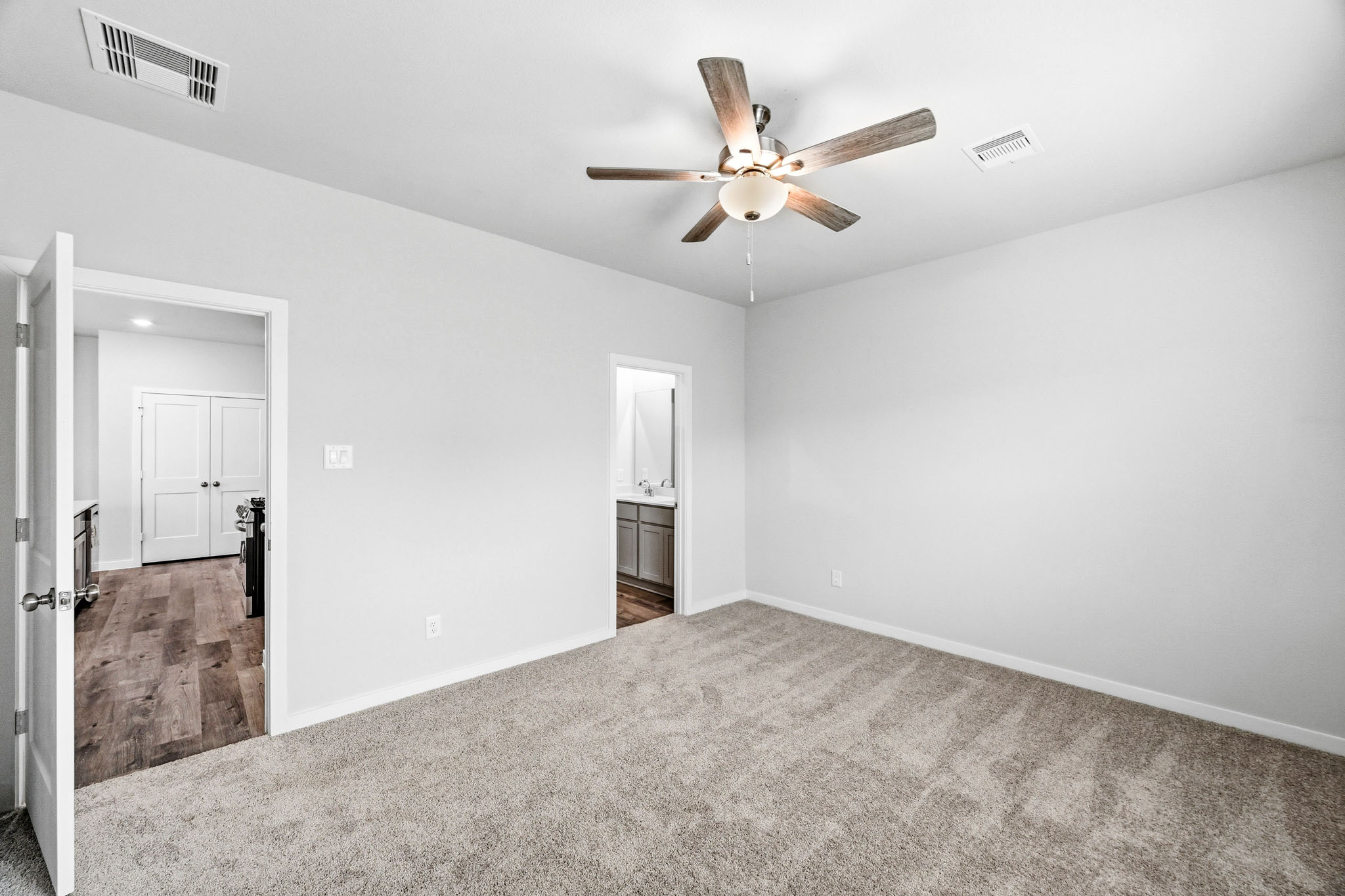 A room with a ceiling fan and a door.