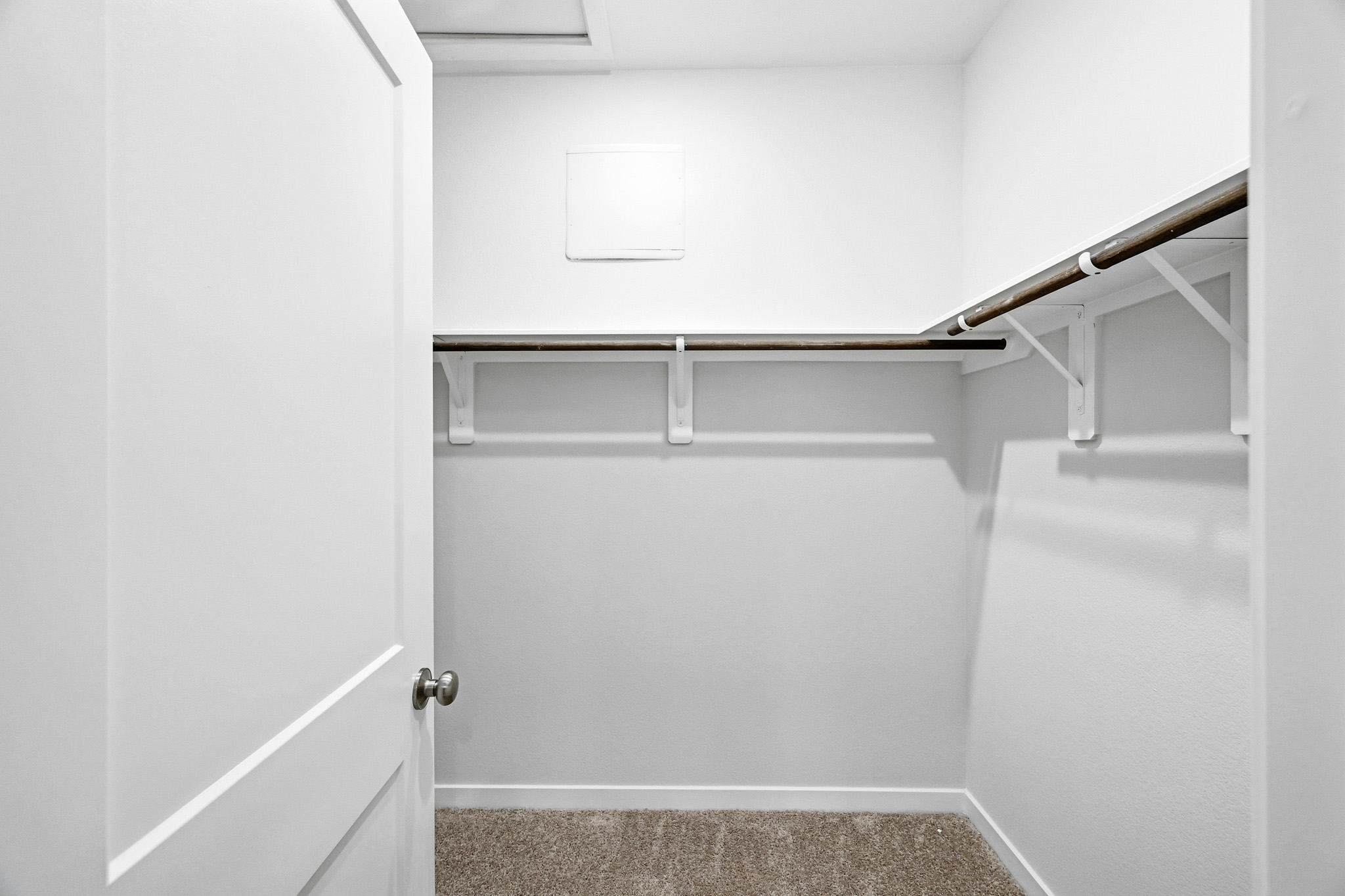 A white room with a white door and a white wall.