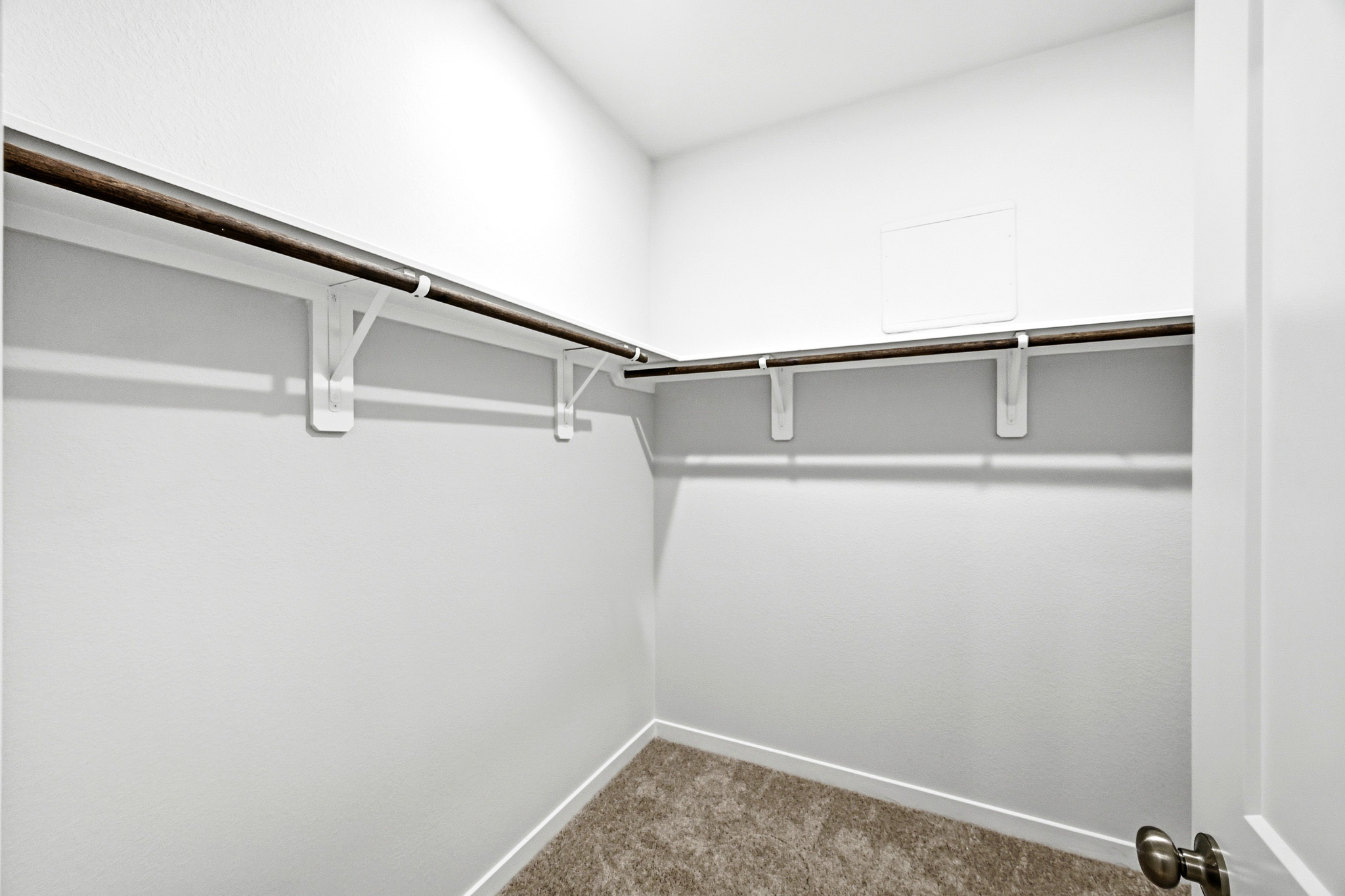 A white wall with a metal bar.