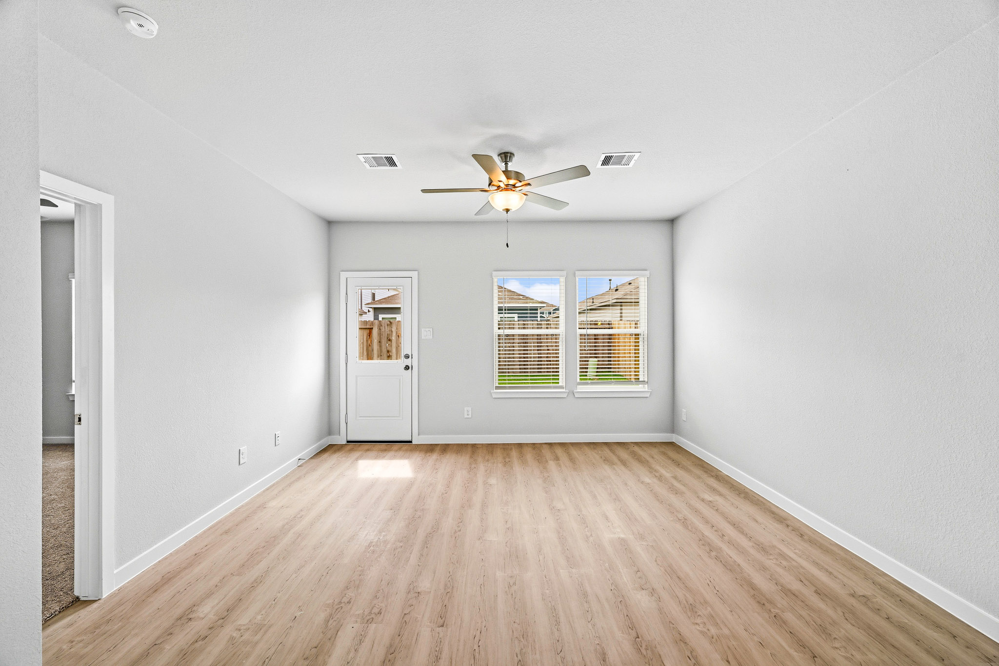 A room with a wood floor and a ceiling fan.