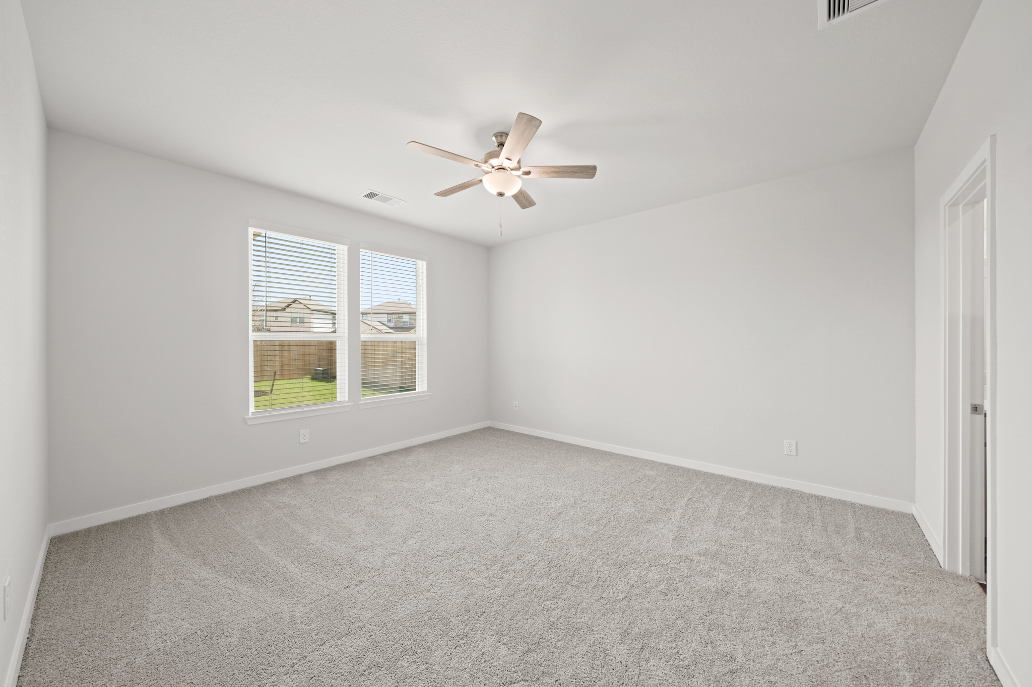A room with a ceiling fan and a window.